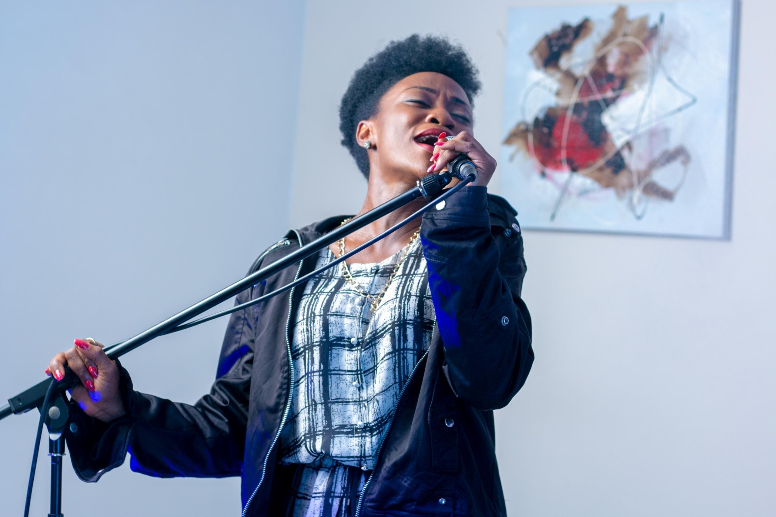 Vrouw zingt met een microfoon in een standaard.