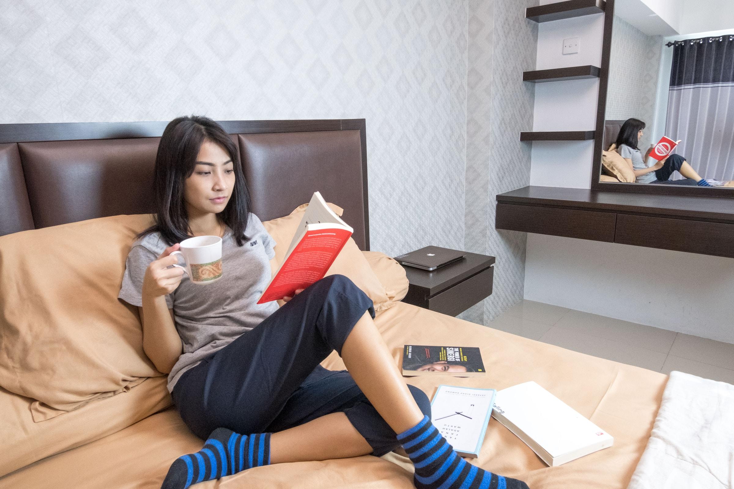 Jonge vrouw lezend op bed