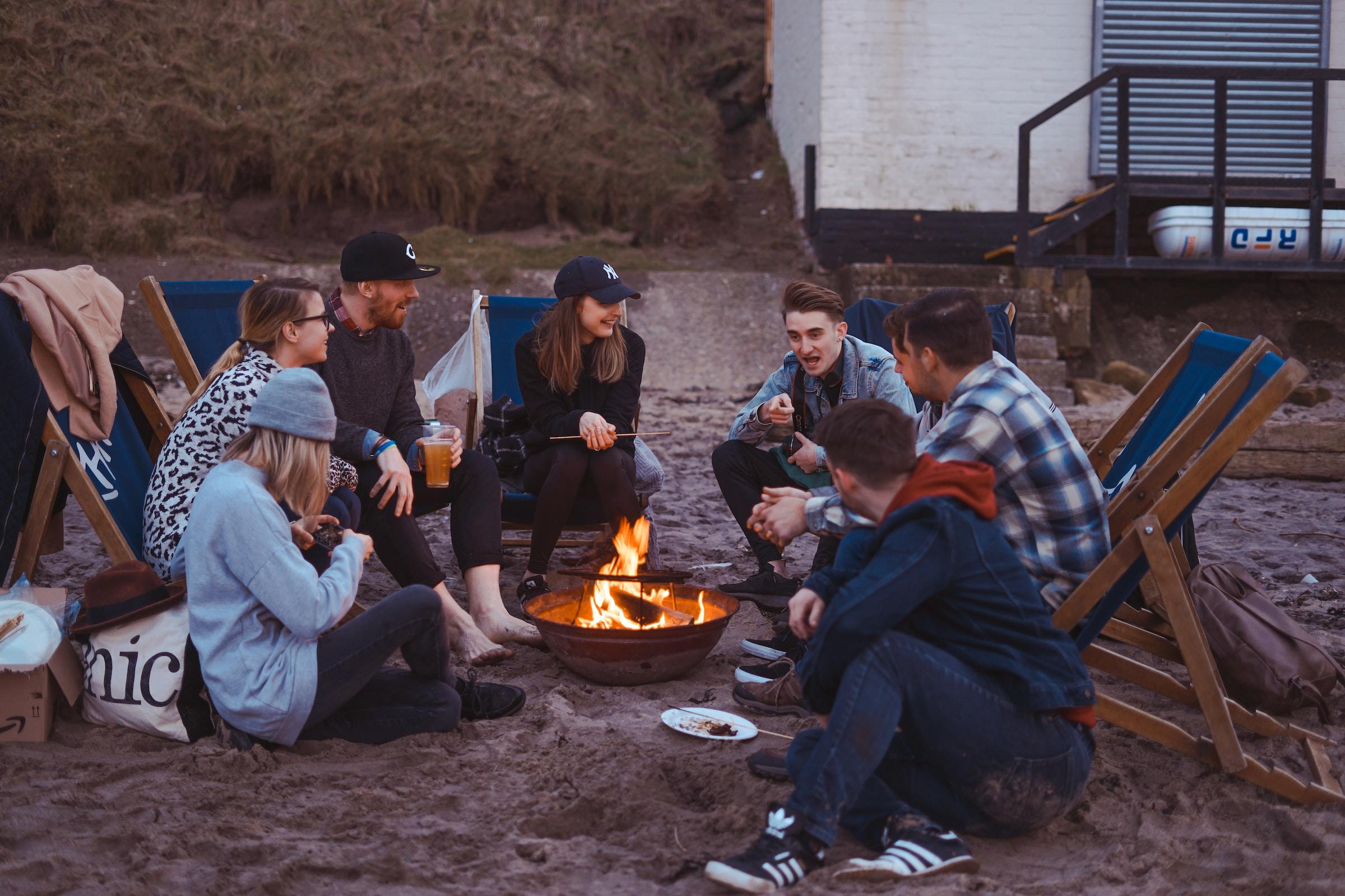 Groep vrienden pratend rond kampvuur