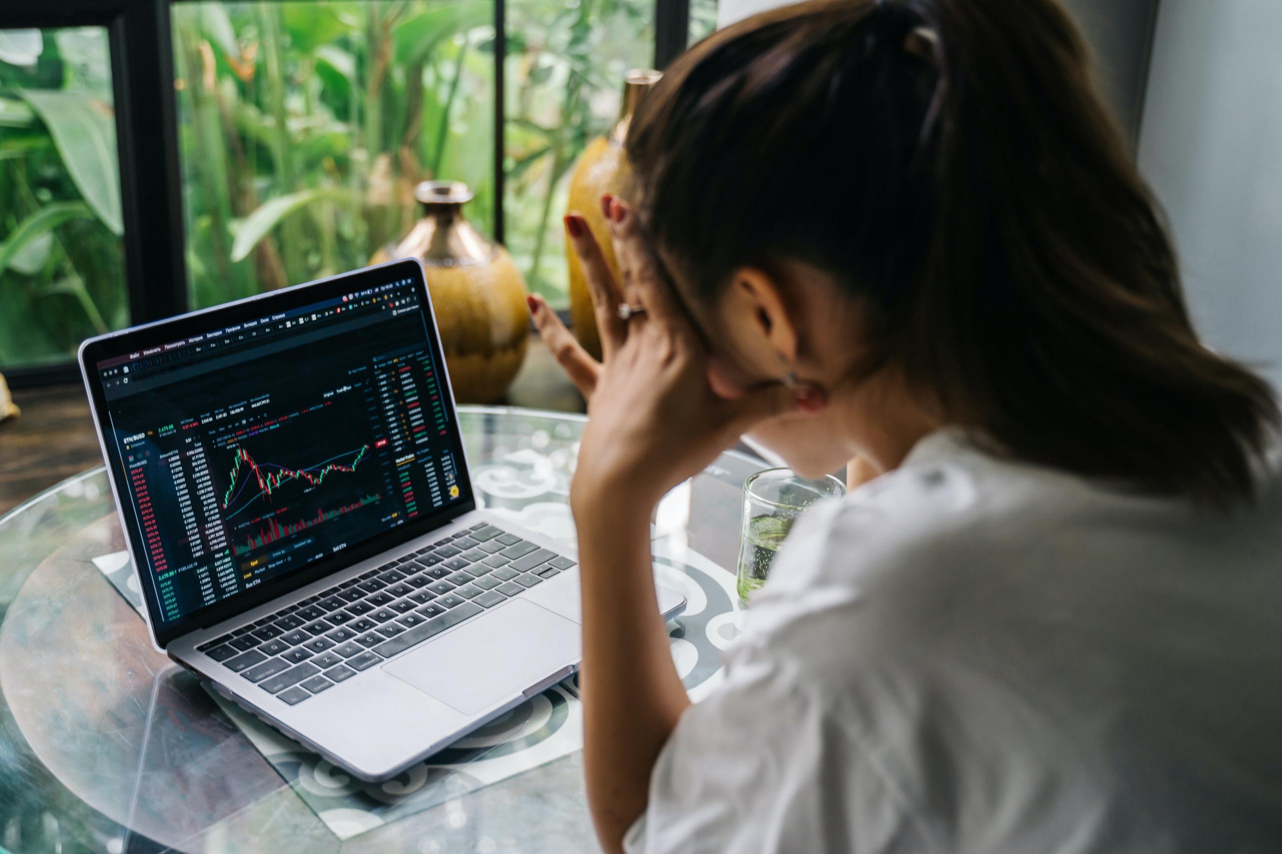 Vrouw zit achter laptop te kijken naar grafiek