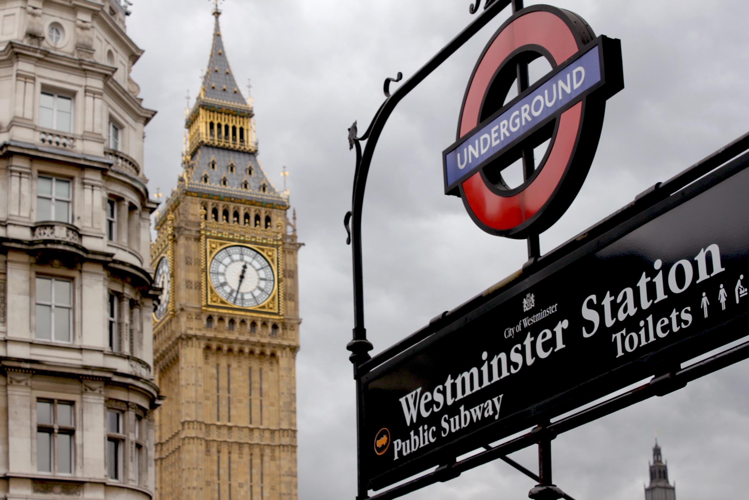 Foto van een metro station met op de achtergrond de Big Ben toren.