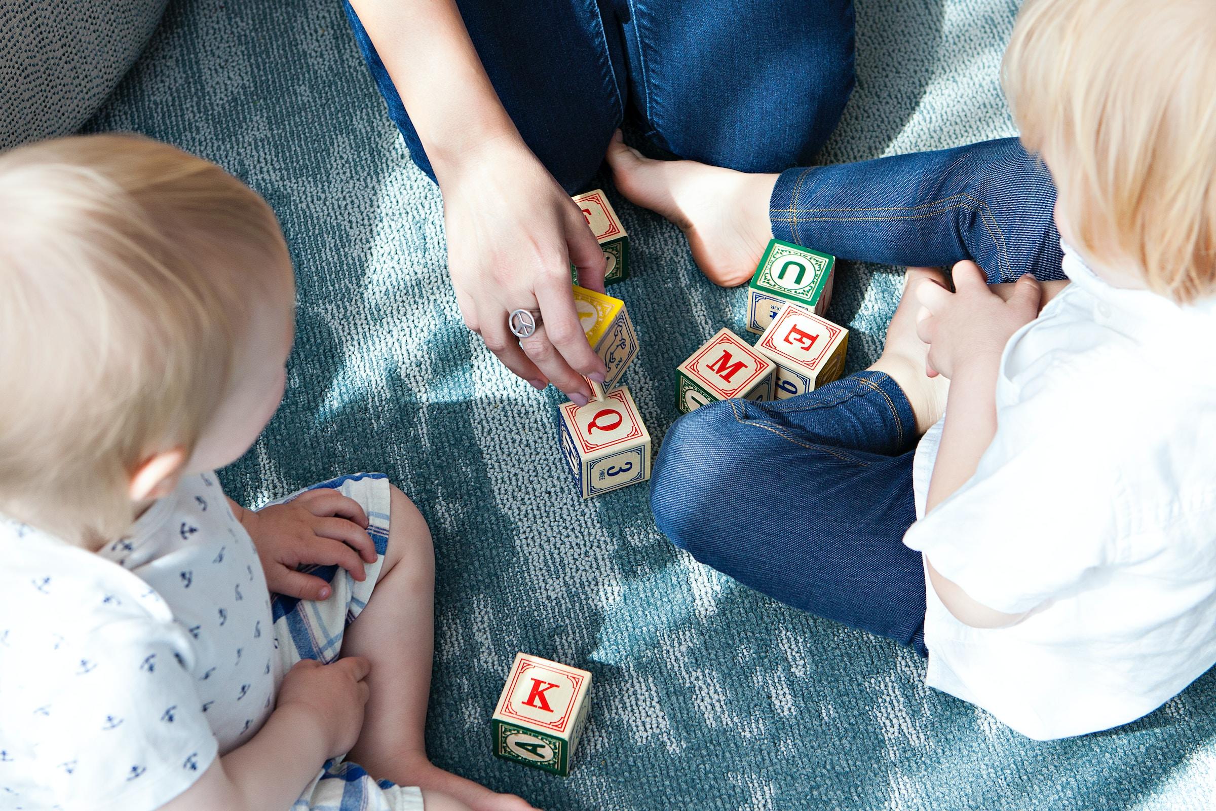 Twee kleine kinderen die met letterblokken spelen