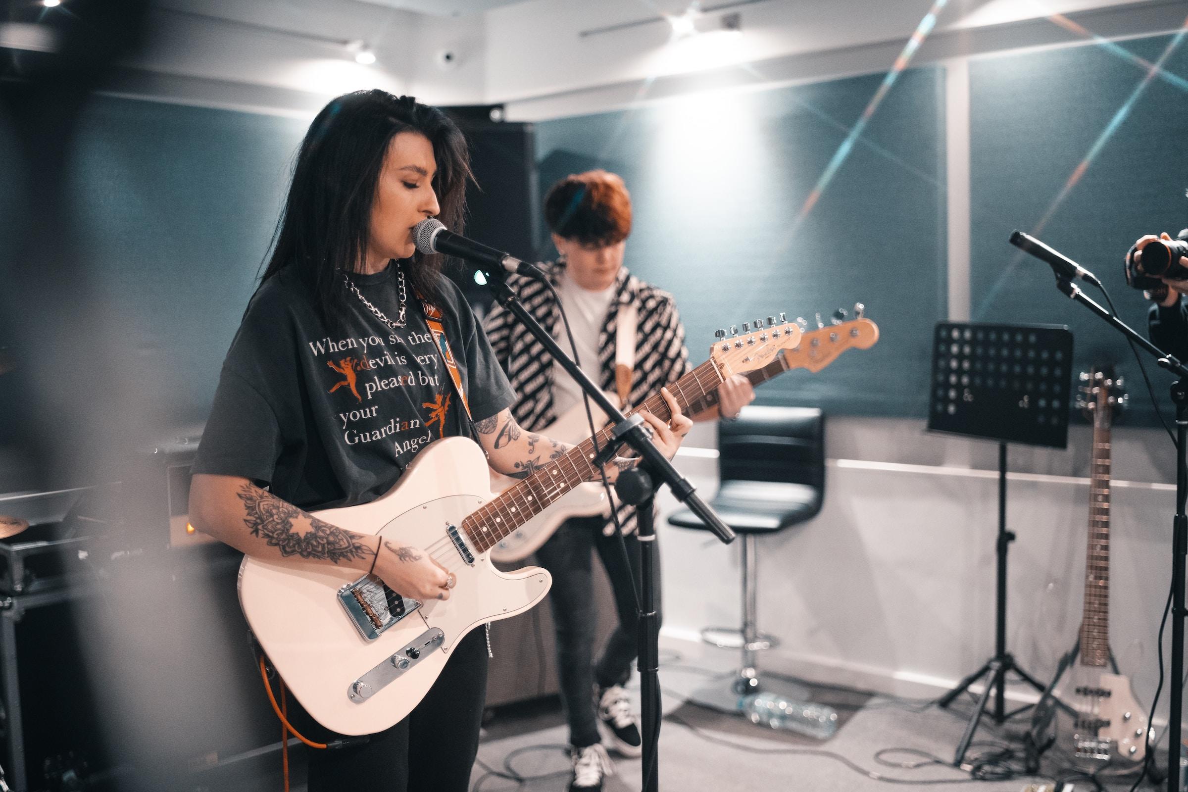 Persoon met gitaar achter microfoon
