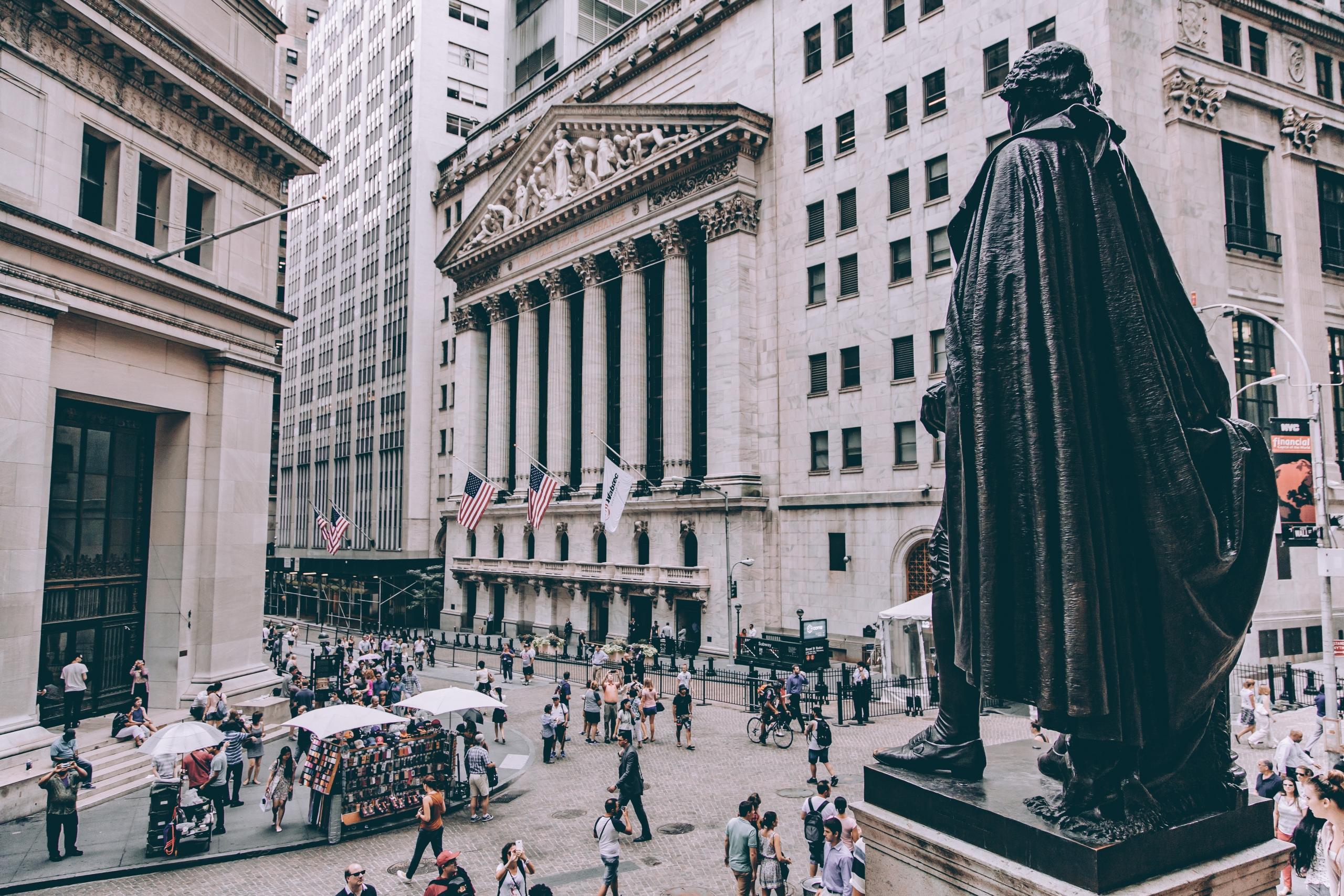 Wall street in New York van buiten met mensen die op straat lopen