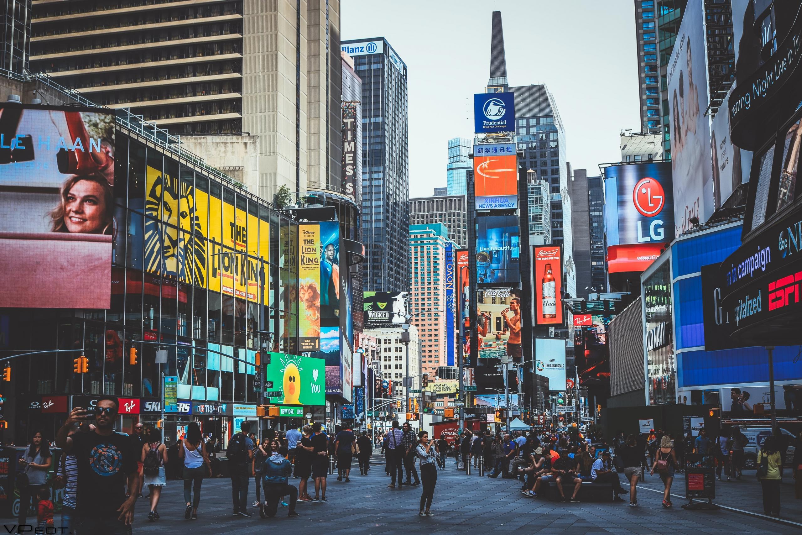Times Square gedurende de dag vol met mensen, gebouwen en reclames.