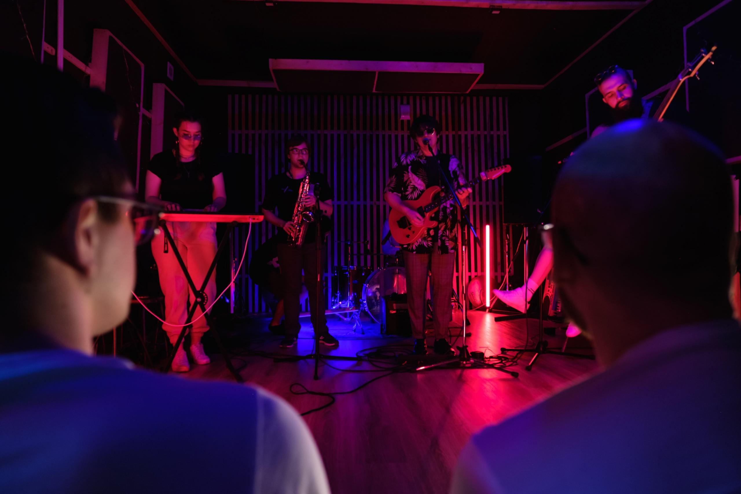 Een band treedt op voor een publiek in een kleine zaal.