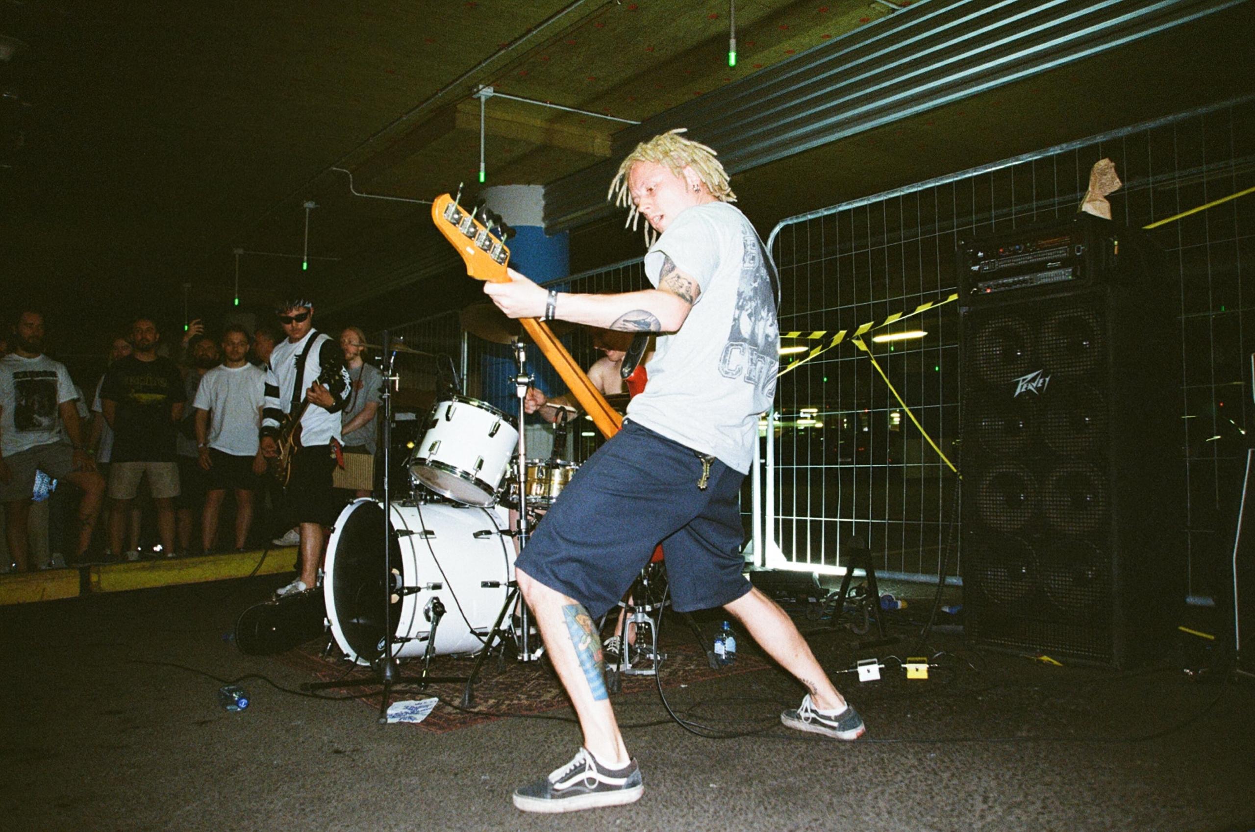 Een bassist in actie tijdens een live-optreden met een energieke houding.