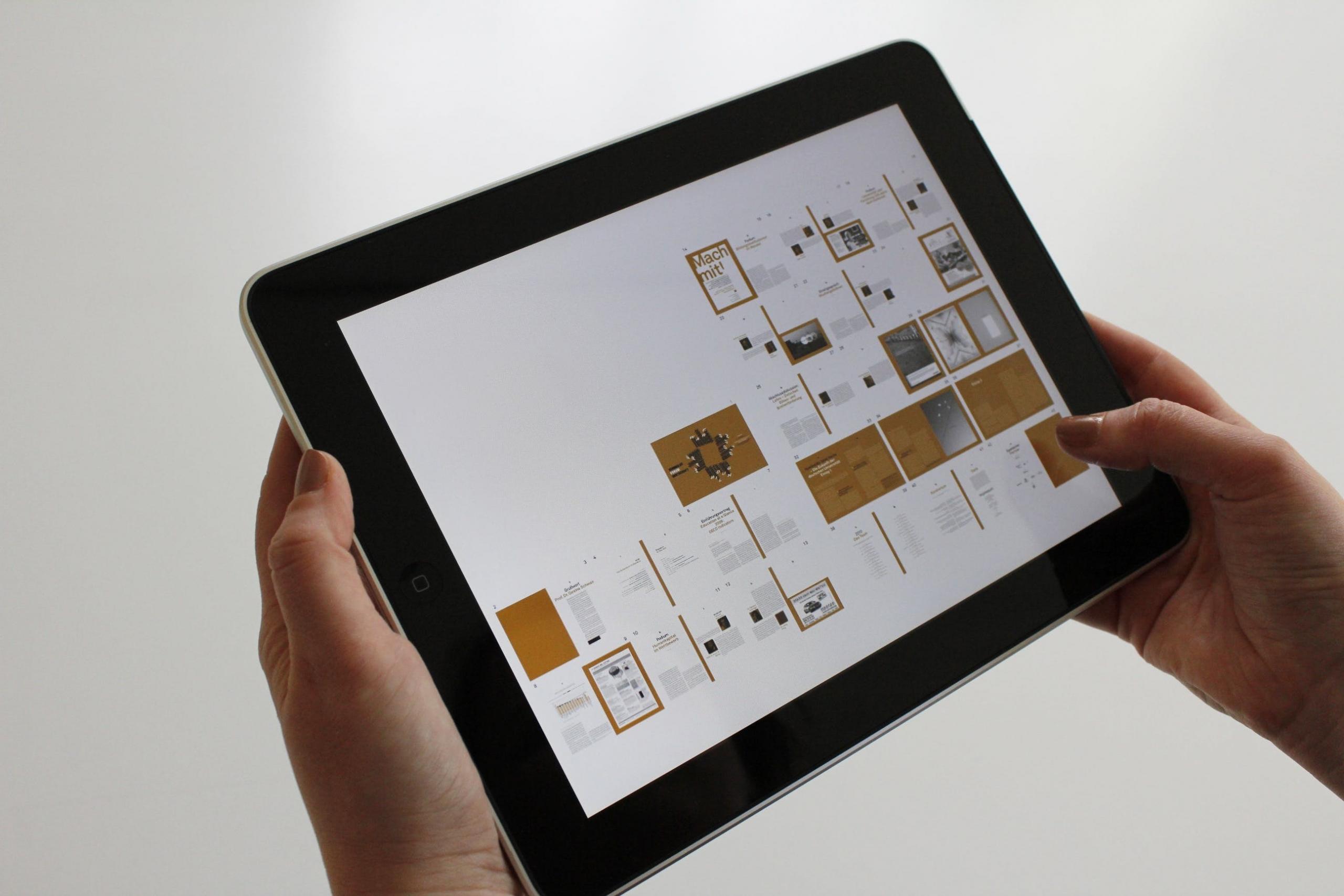 Een hand houdt een tablet vast met een grafische presentatie erop.
