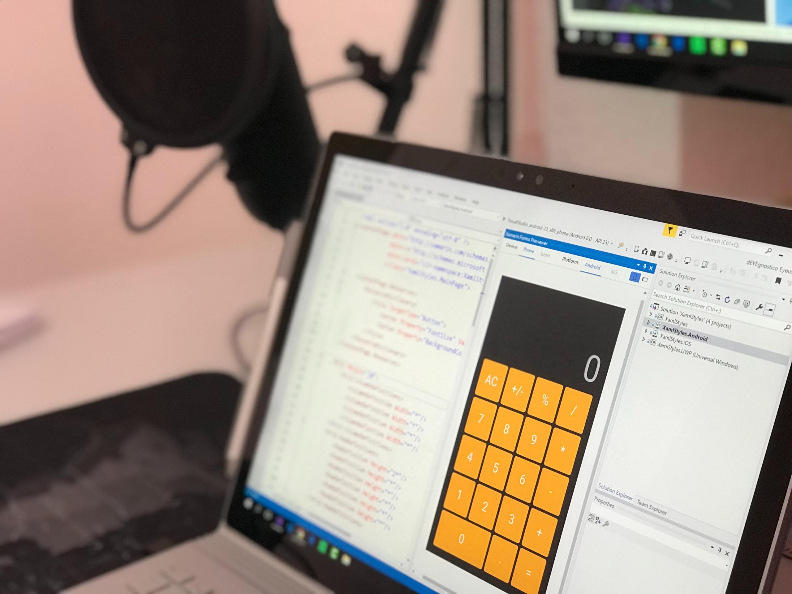 Een laptop met code en een app-ontwerp op het scherm.