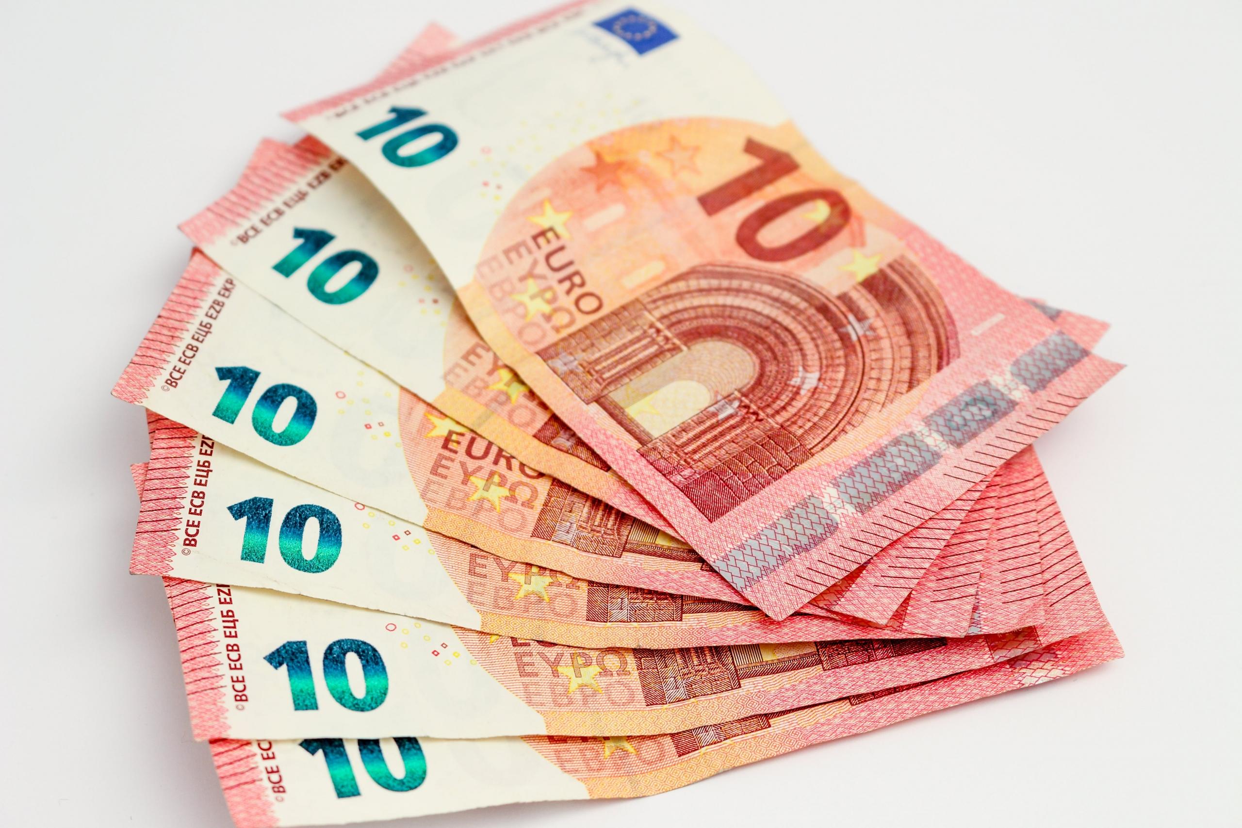 Tien eurobiljetten liggen op elkaar gestapeld.