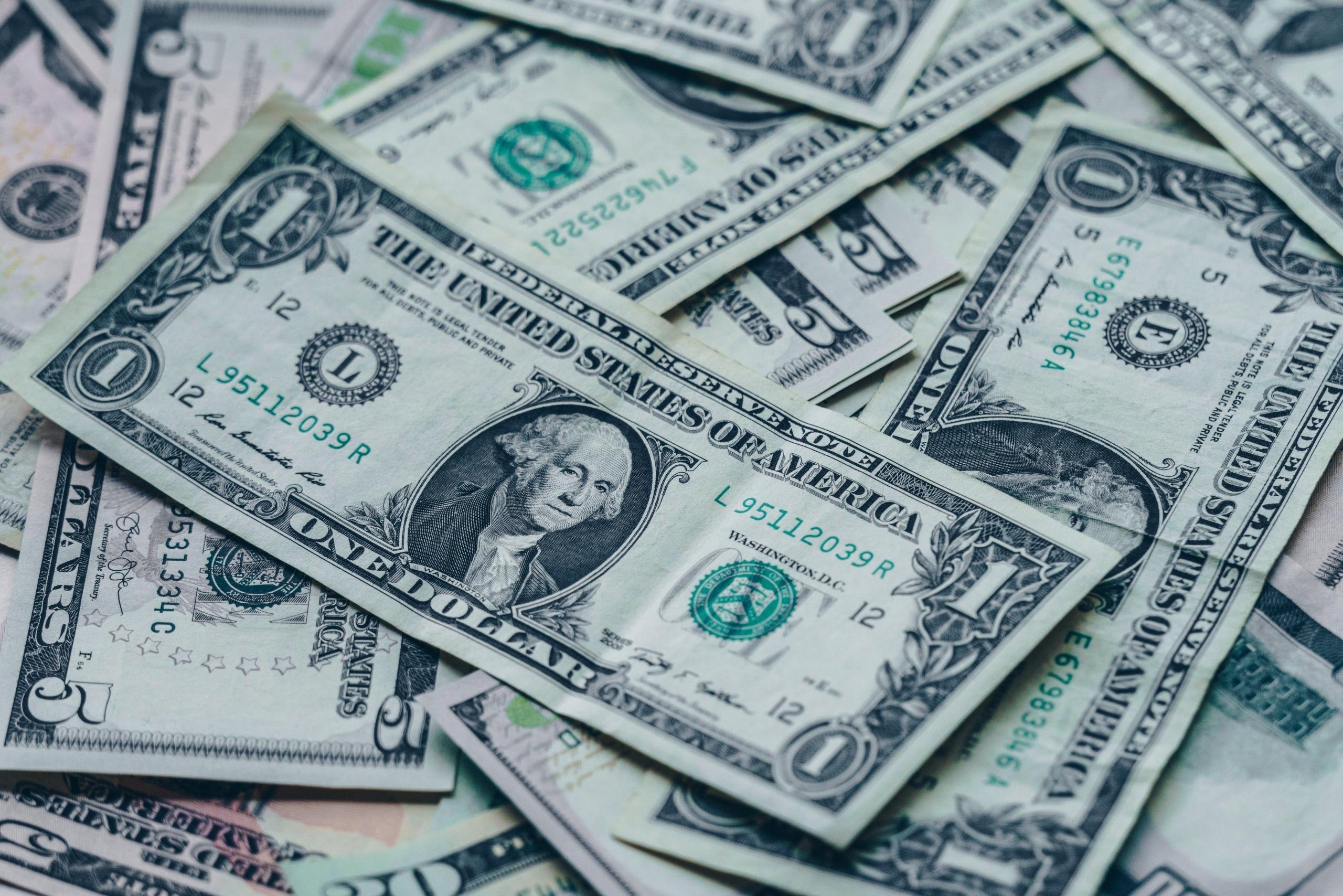 Amerikaanse dollarbiljetten van verschillende waarden liggen verspreid.