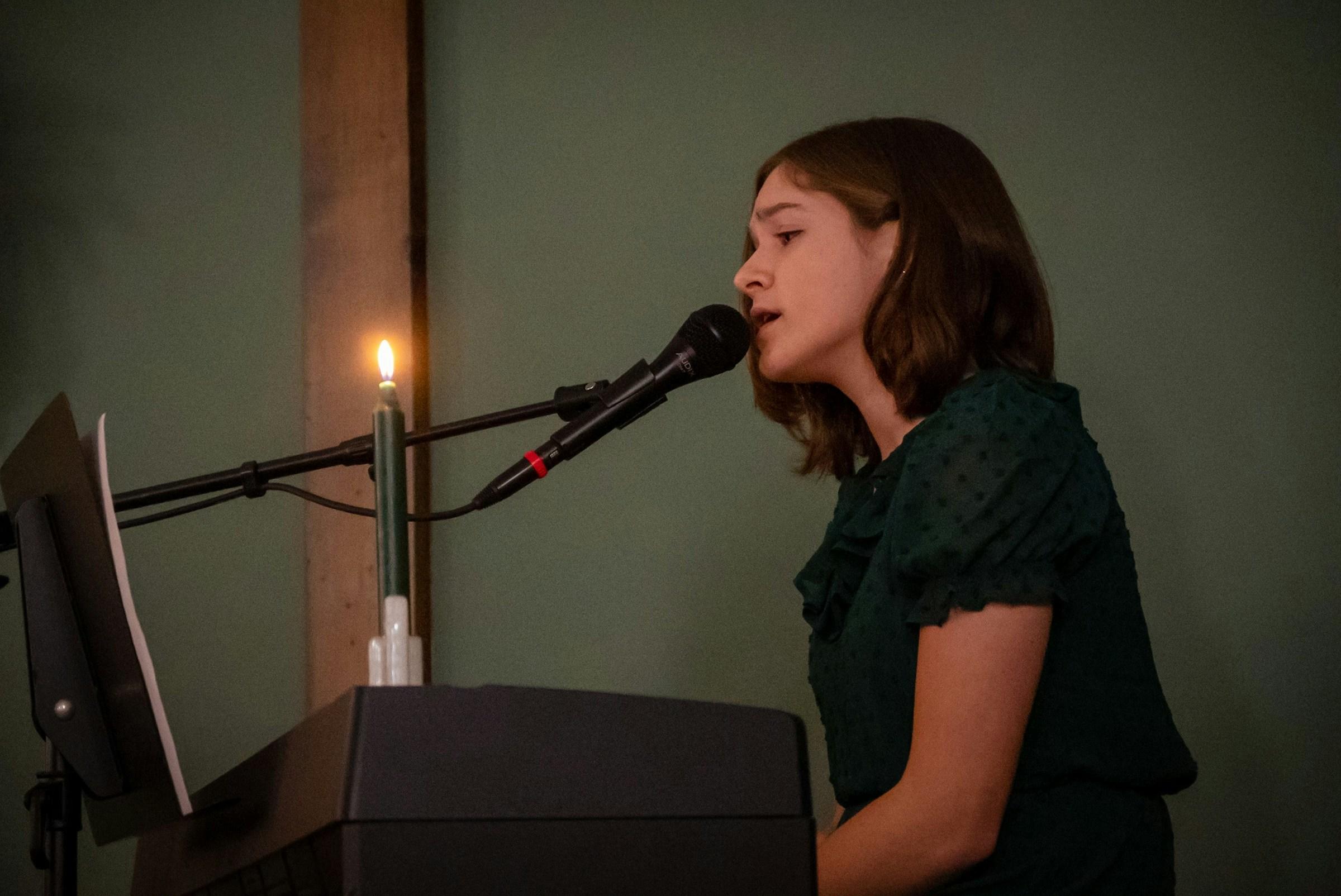 Zingende vrouw achter microfoon met een kaars voor haar