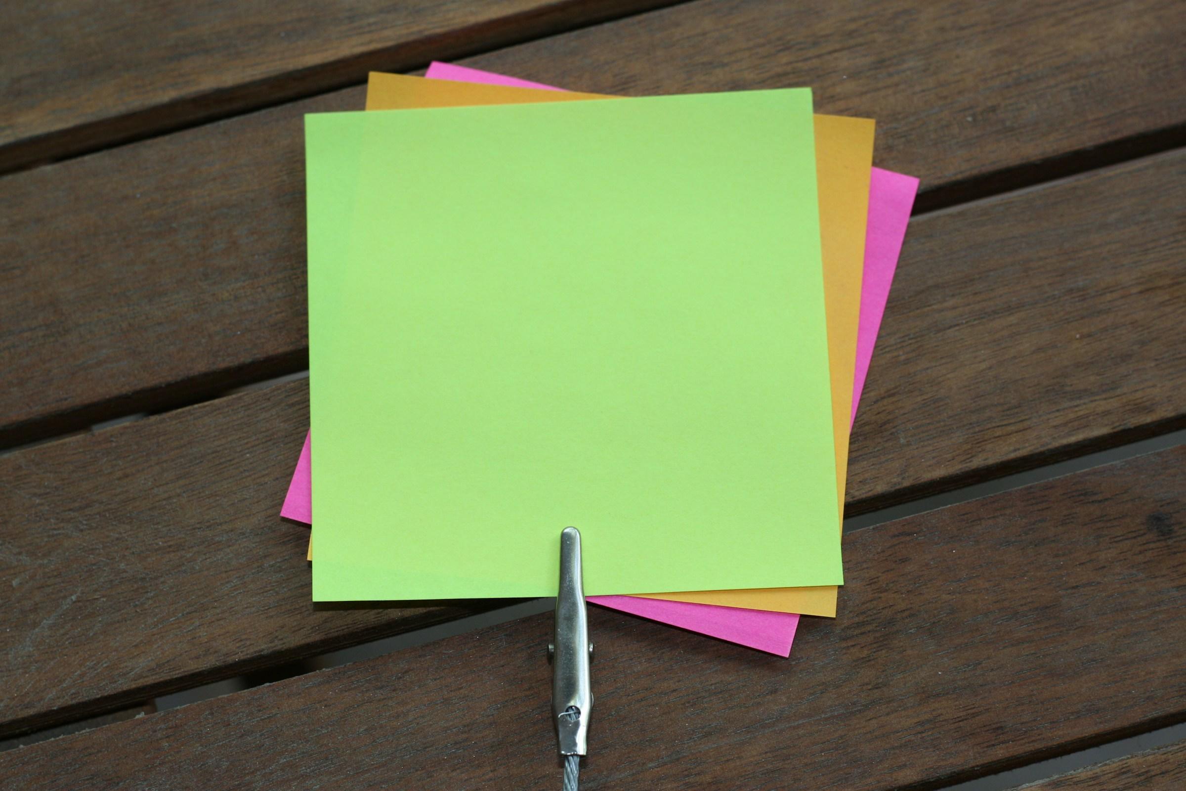 Stapeltje gekleurde post-its aan clip