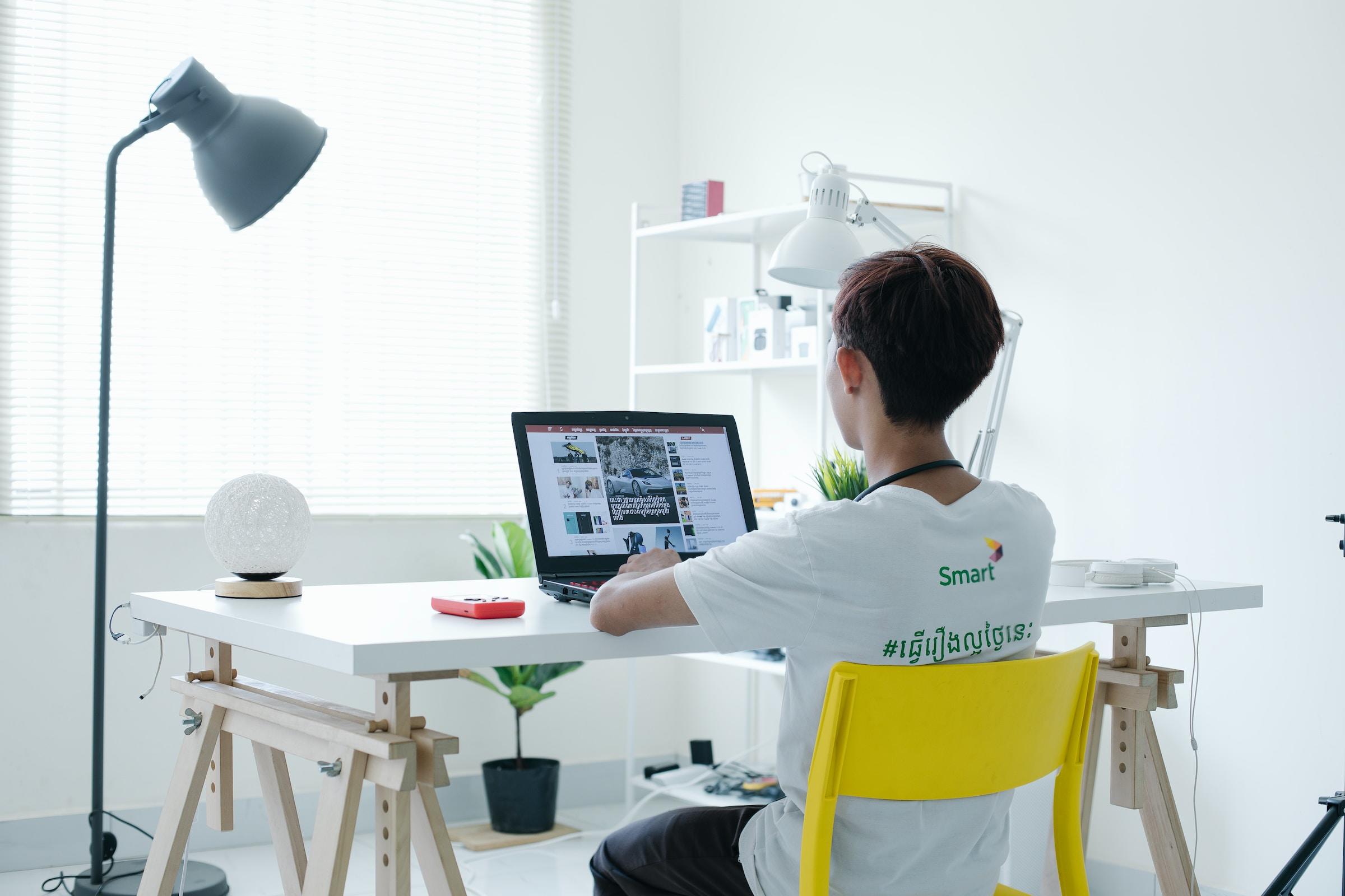 Persoon achter laptop aan tafel