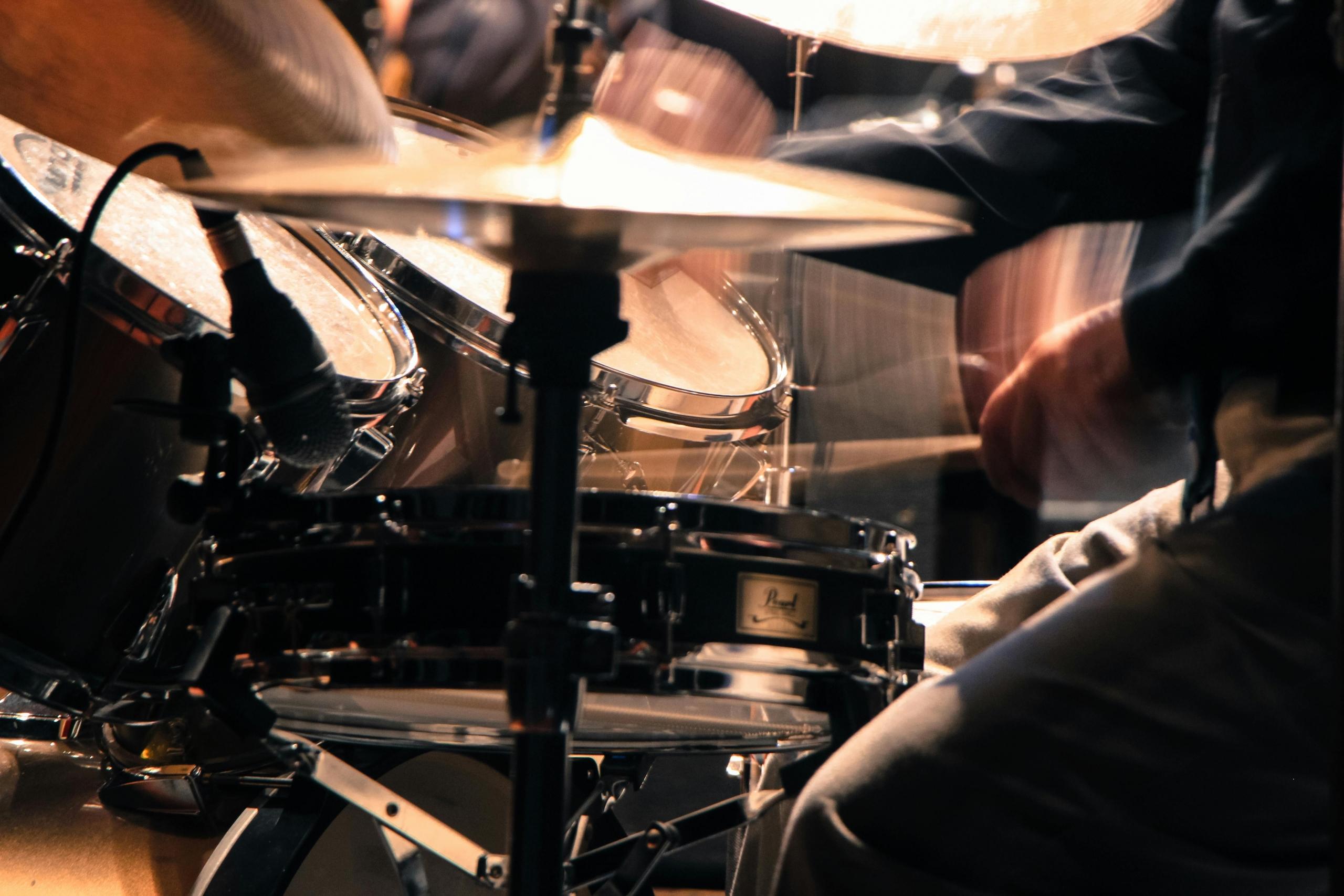 Een drummer in actie, gefocust op het bespelen van een drumstel.