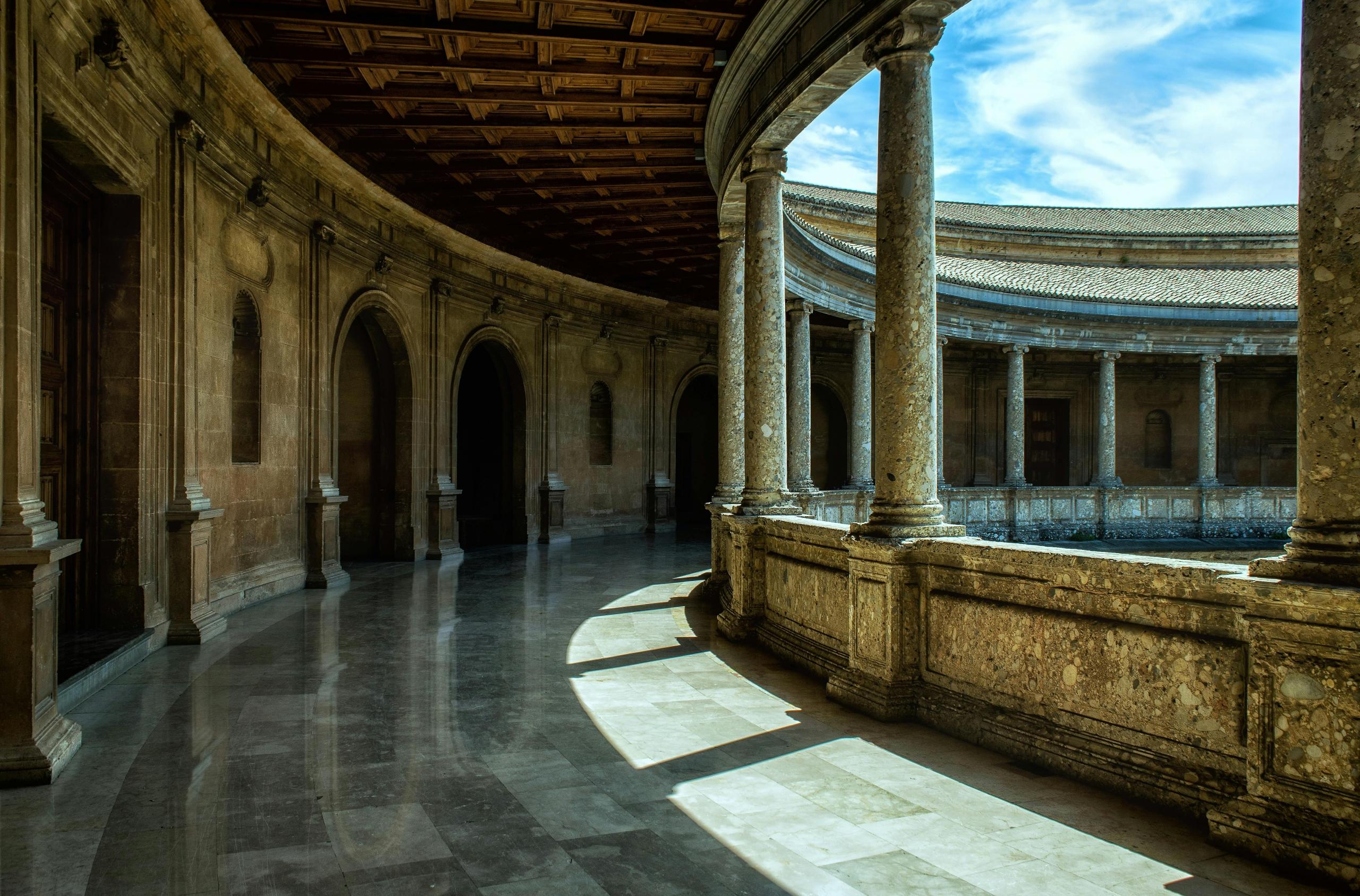 Een deel van het Alhambra in Granada, met een blik op de binnenplaats met zijn karakteristieke zuilengalerijen en gedetailleerde architectuur.