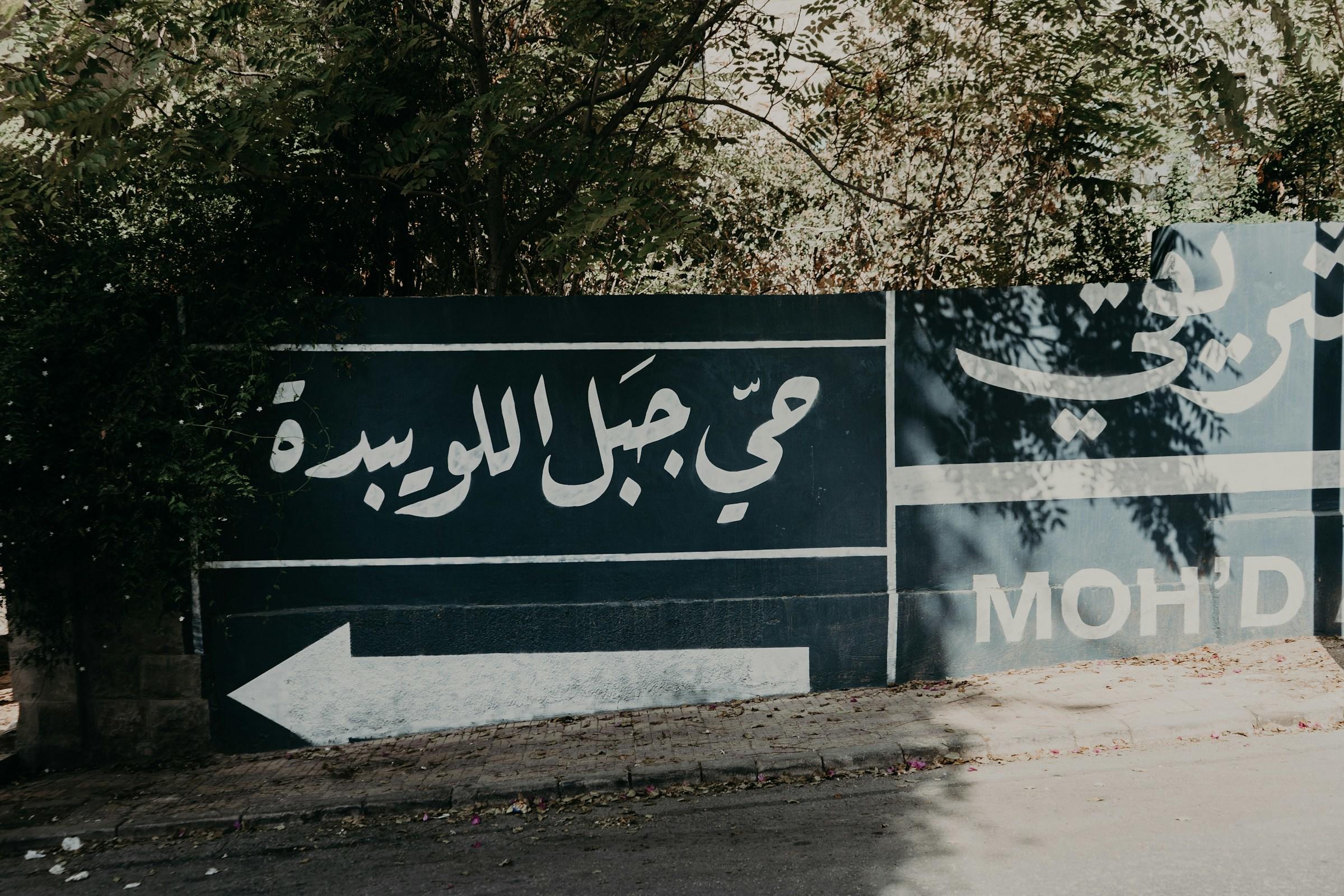 Arabische letter en witte pijl op een zwart bord