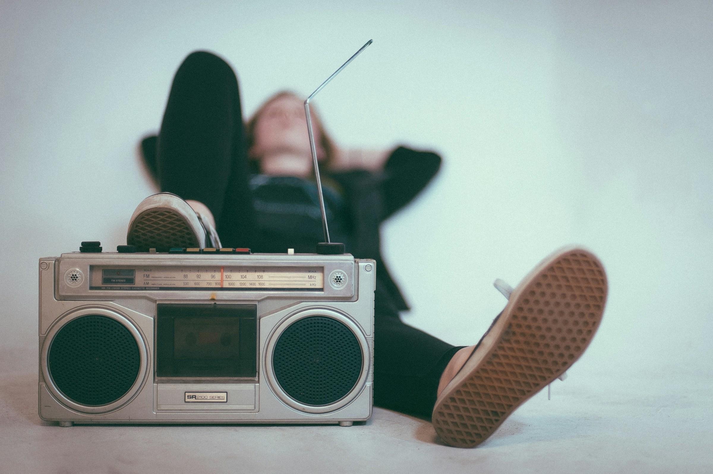 Liggende persoon met transistor radio aan zijn voeten