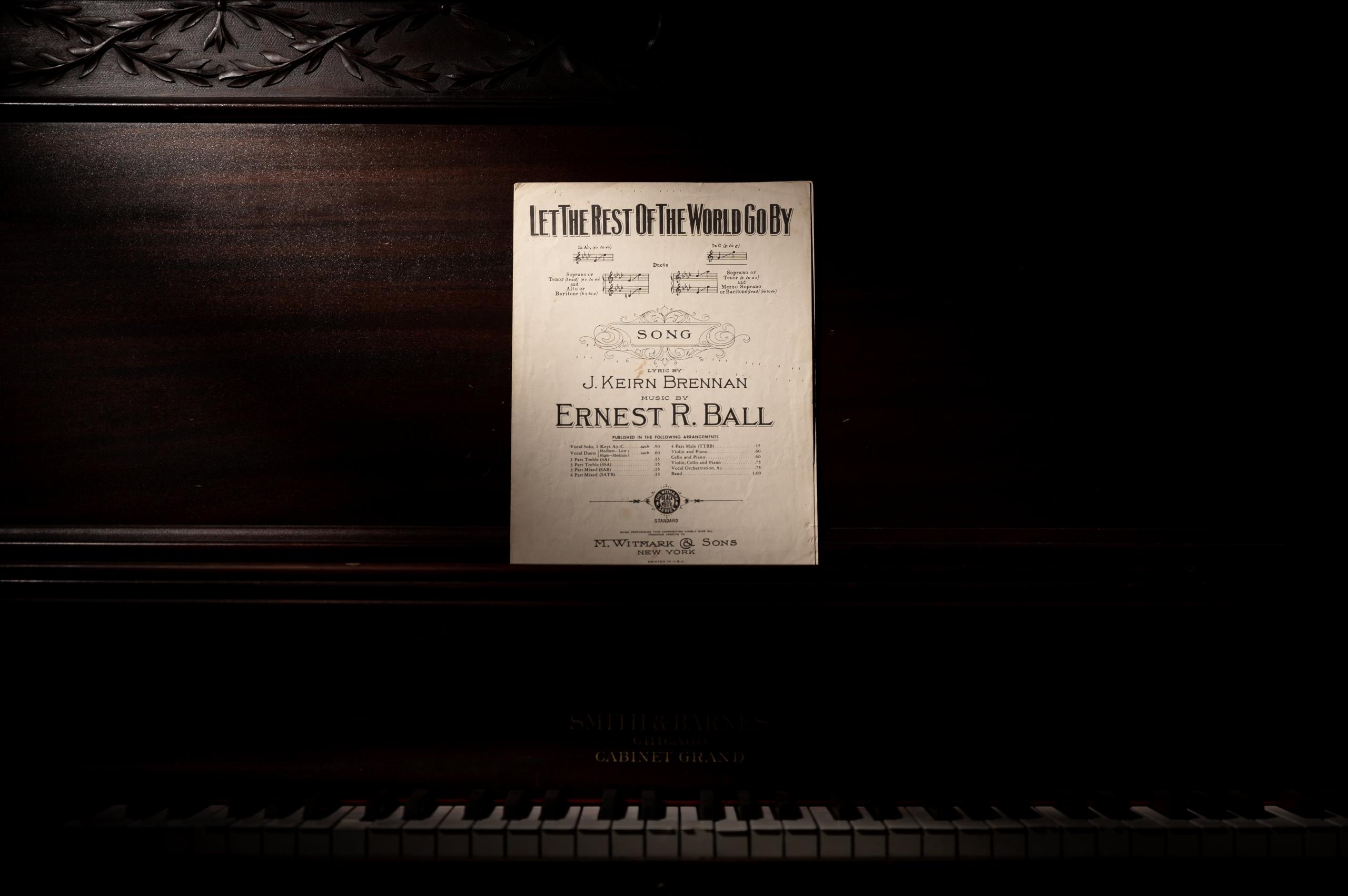 Het toetsenbord van een piano met daarboven geplaatst bladmuziek.