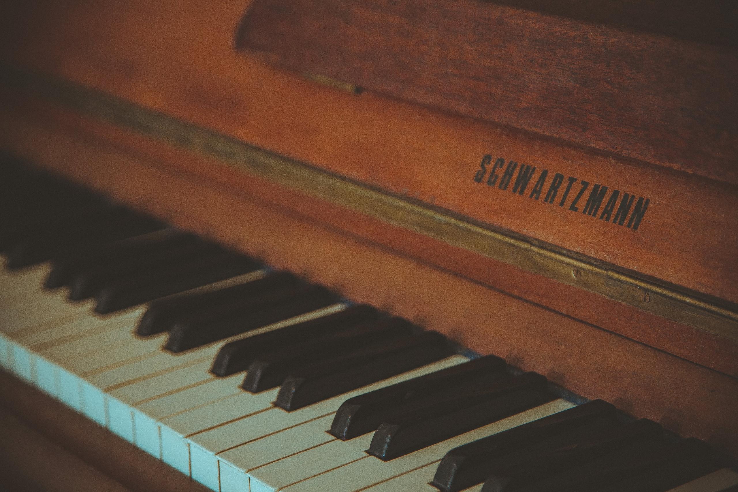 Houten piano met de naam 'Schwarzmann' erop.