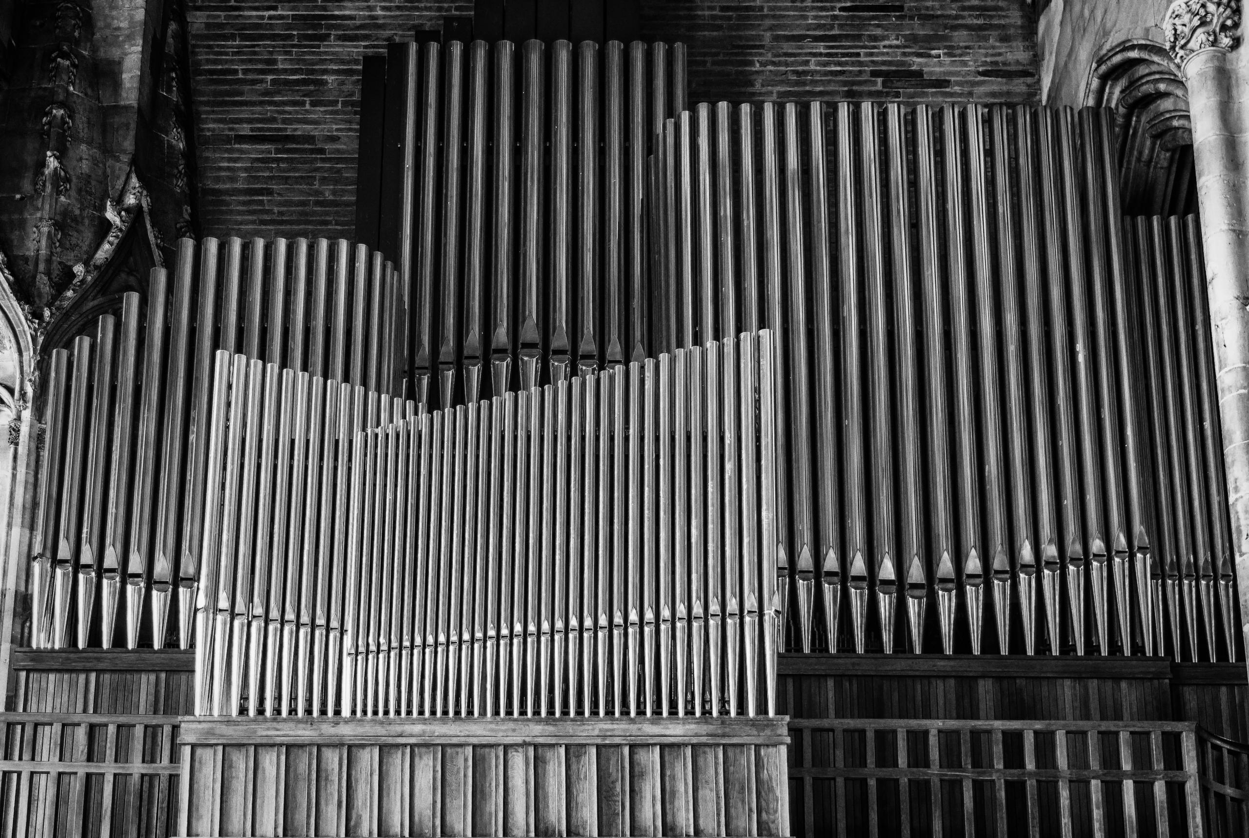 Een groot orgel in een kerk afgebeeld in zwart-wit.