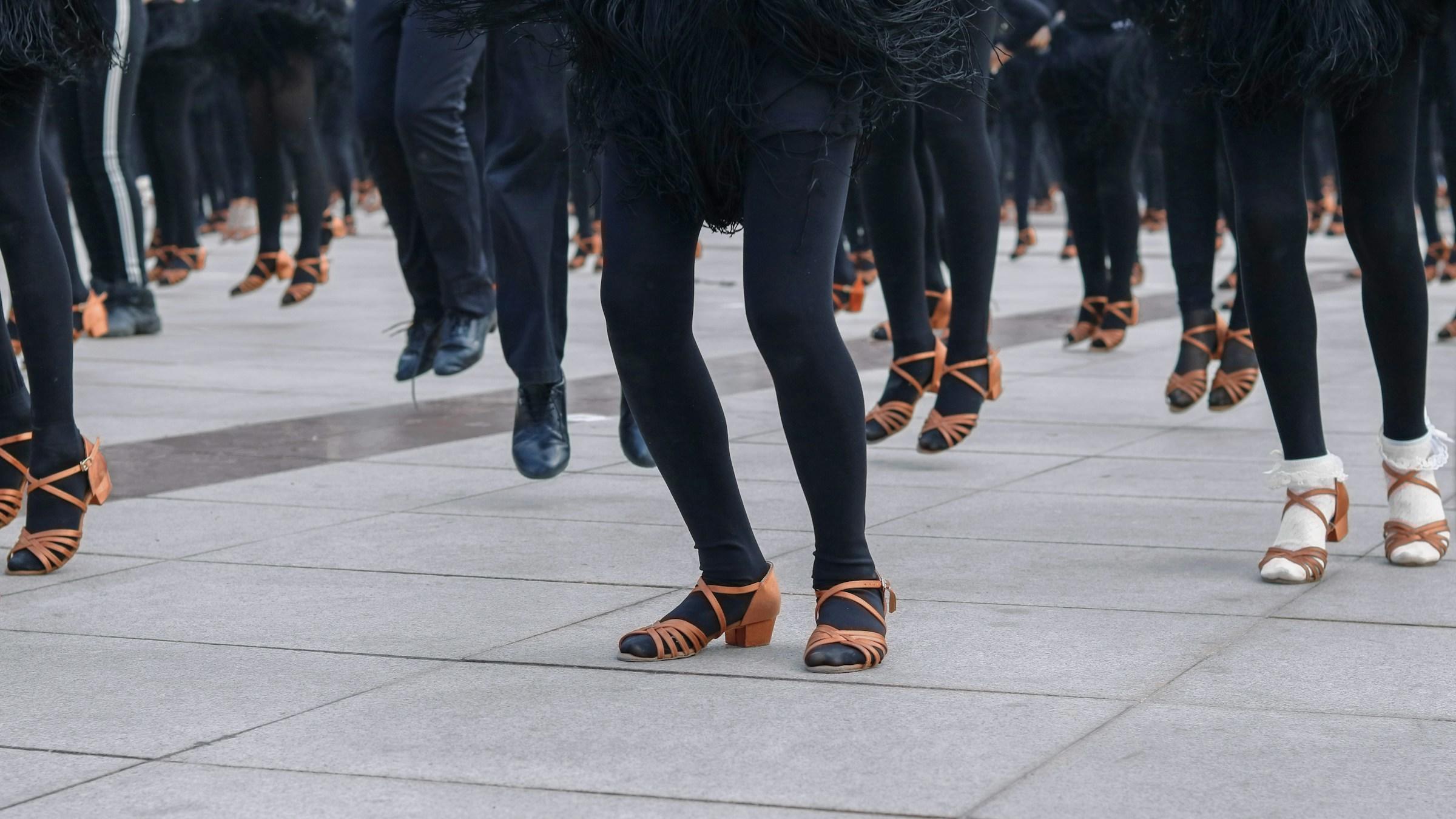 Bewegende voeten met bruine sandalen en zwarte schoenen