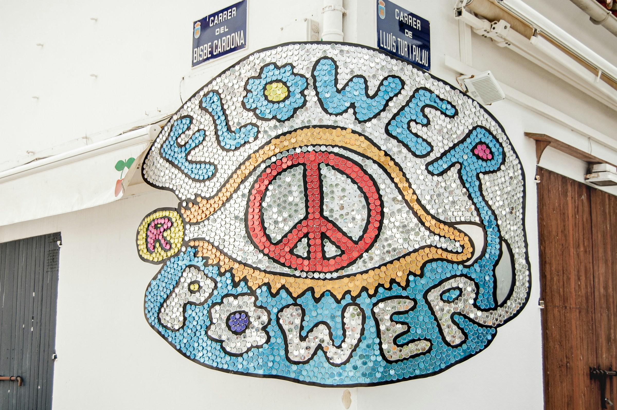 De woorden Flower Power en een vredesteken op uithangbord van pailletjes