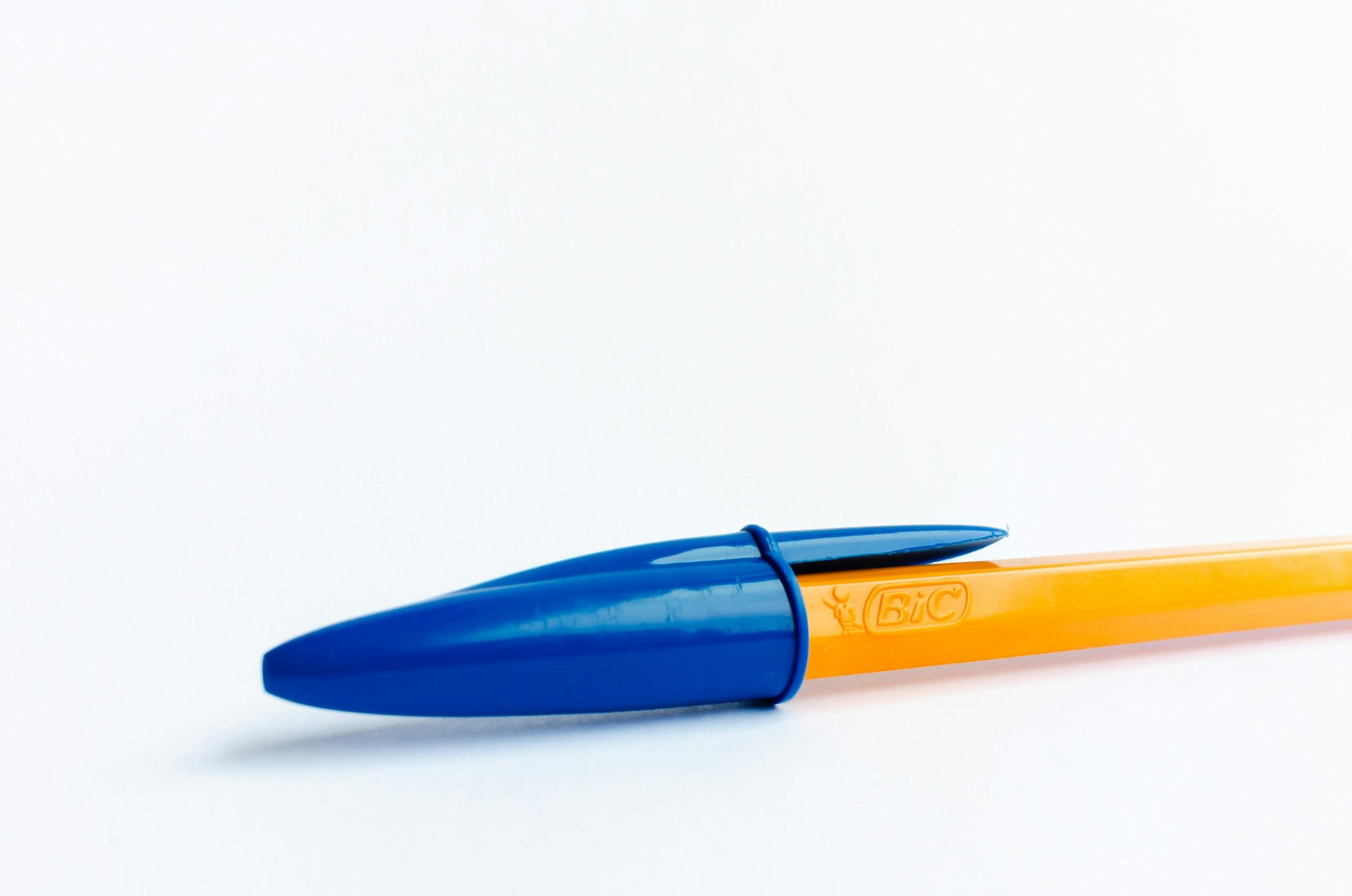 Gele BIC pen met blauwe dop op witte achtergrond
