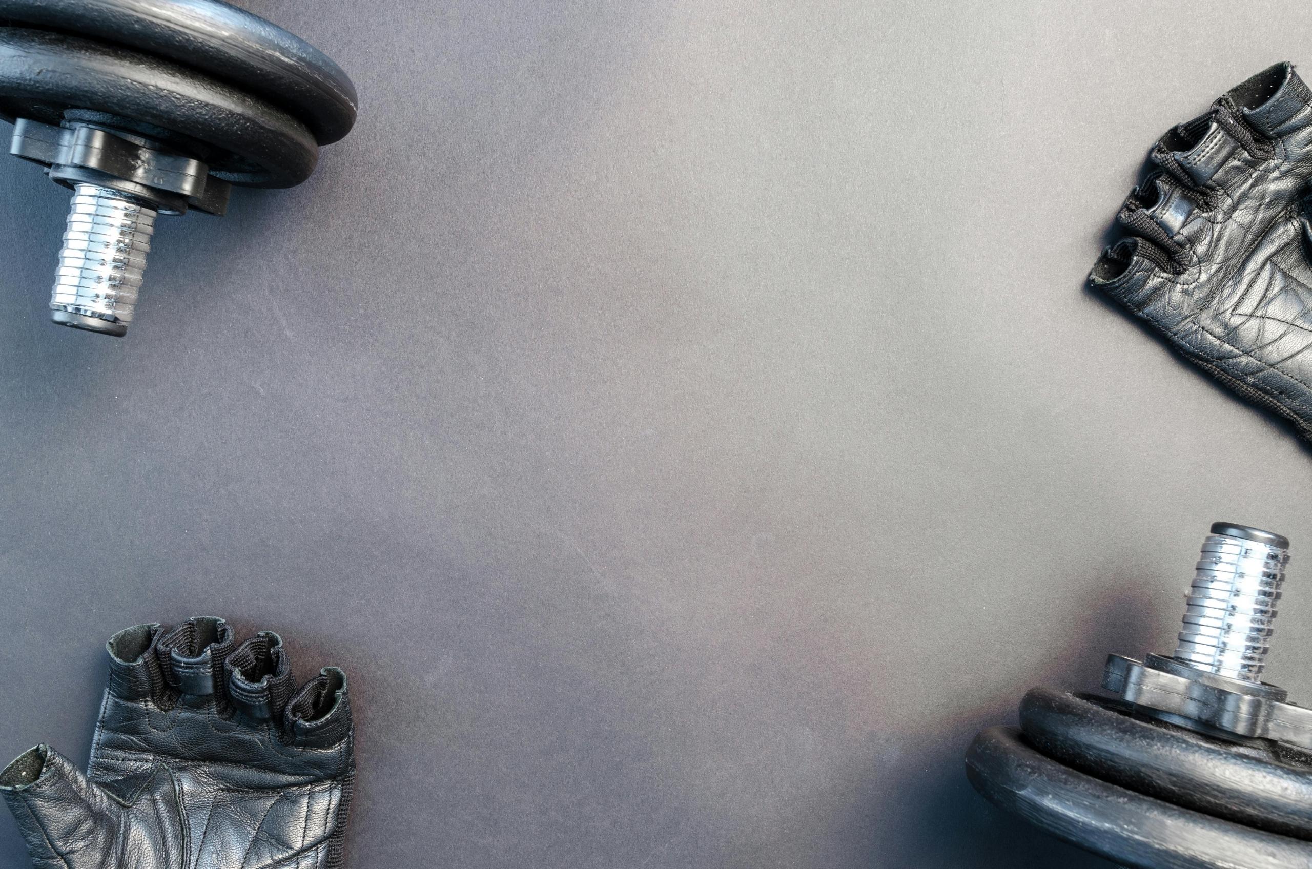 Sportuitrusting inclusief dumbbells en gymhandschoenen tentoongesteld.