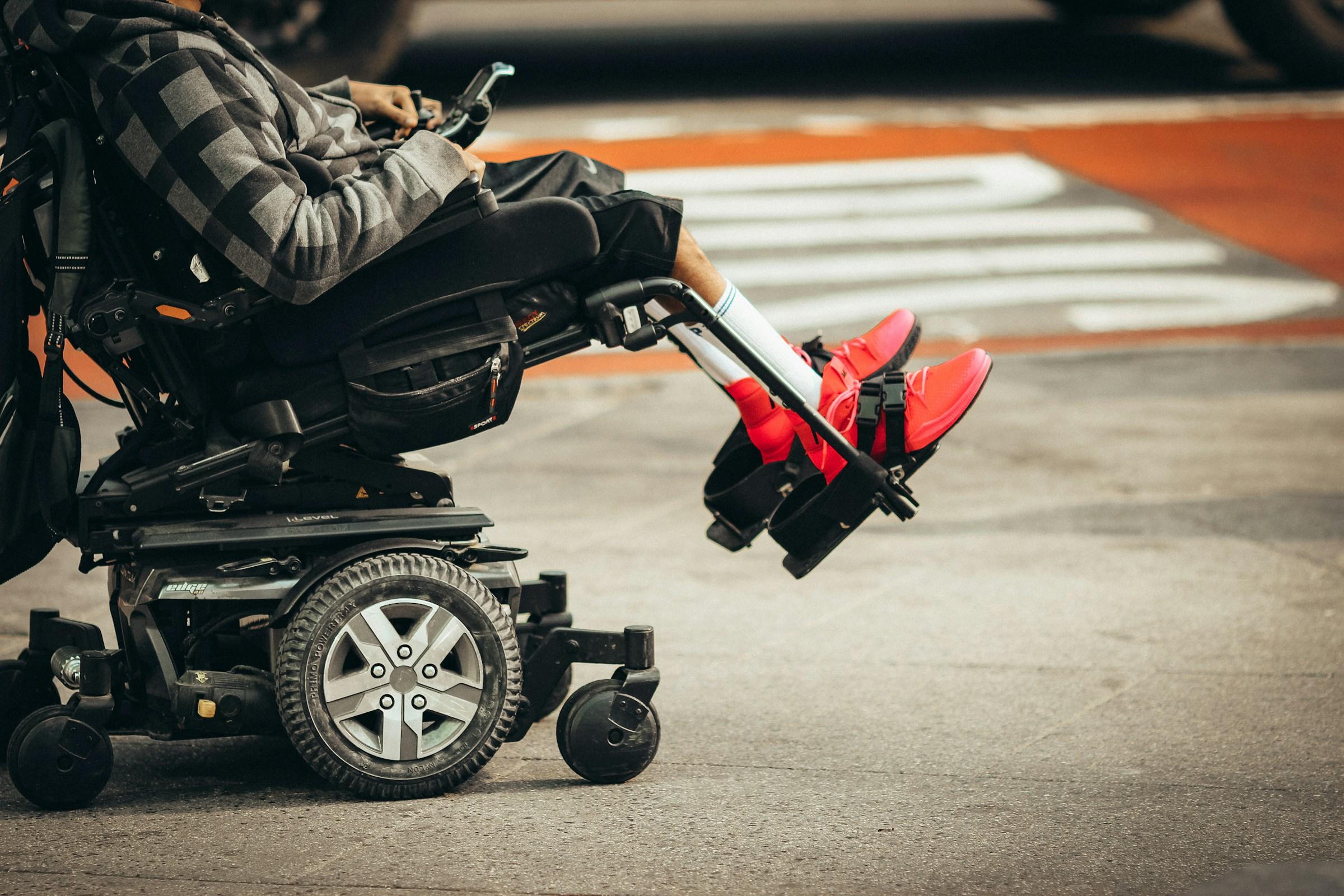 Persoon met rode schoen zit in rolstoel gehandicapten