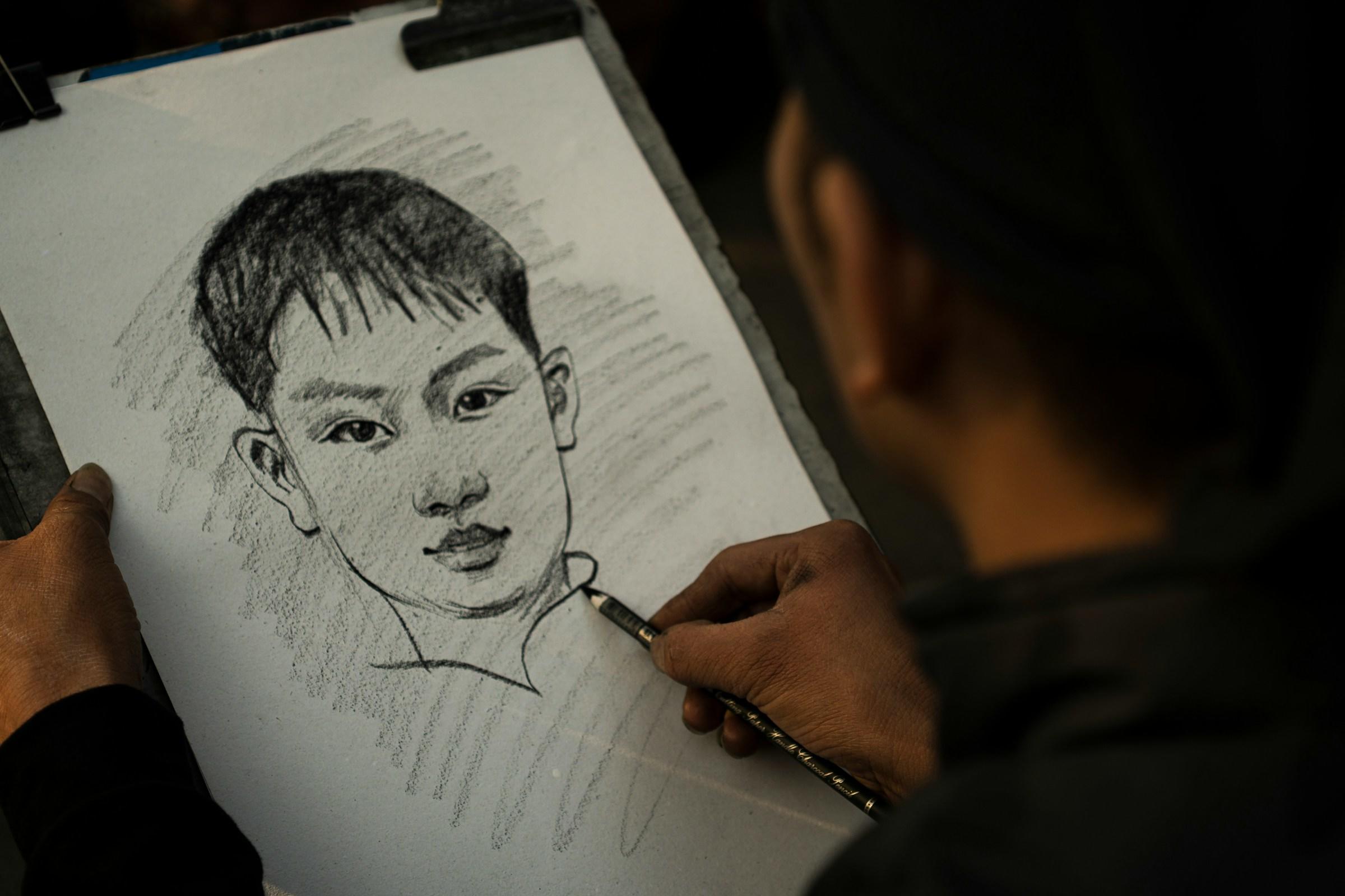 Persoon met houtskoolpotlood in hand maakt portret
