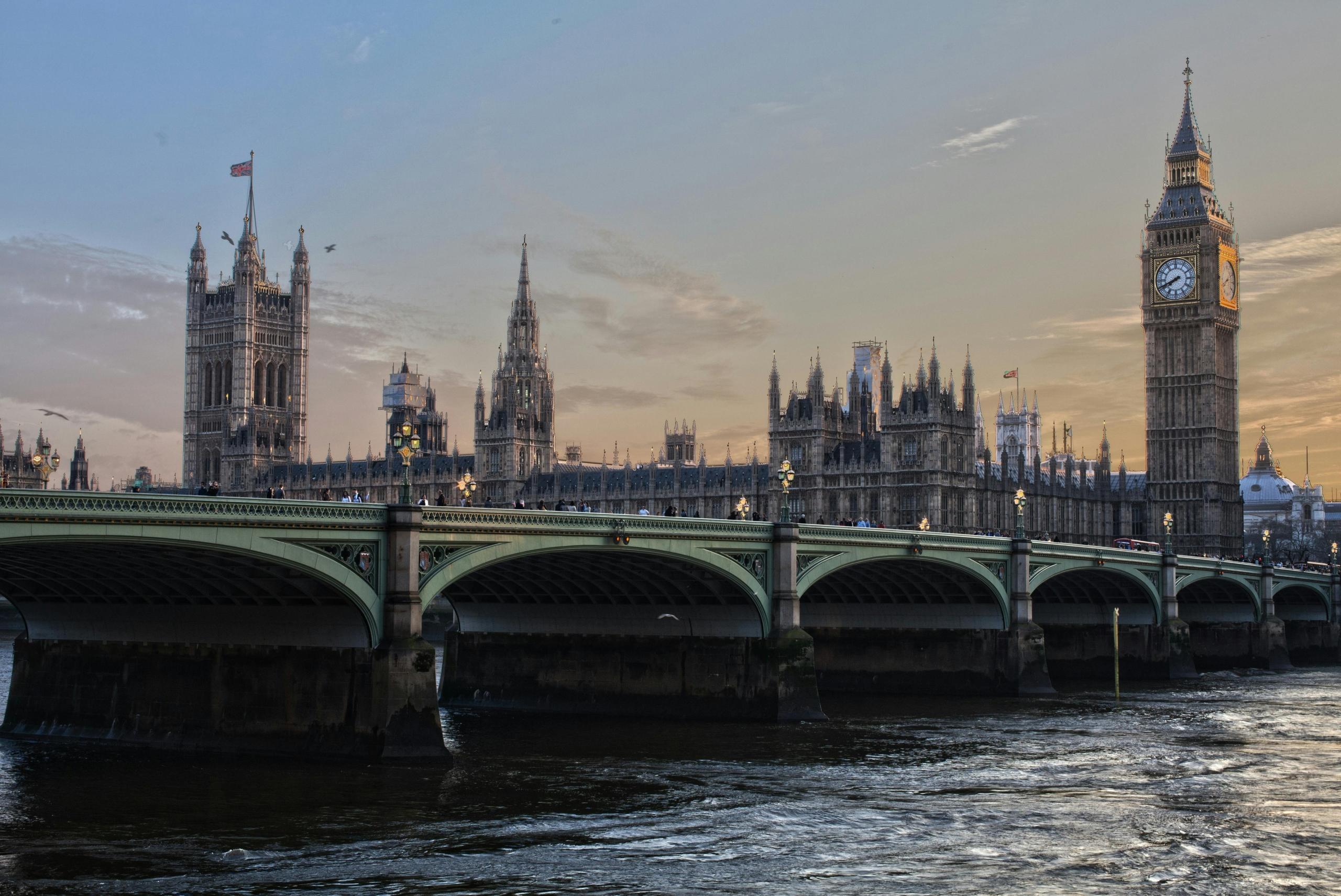 Een zonsondergang uitzicht op de Houses of Parliament en de Big Ben in Londen met brug op de voorgrond.
