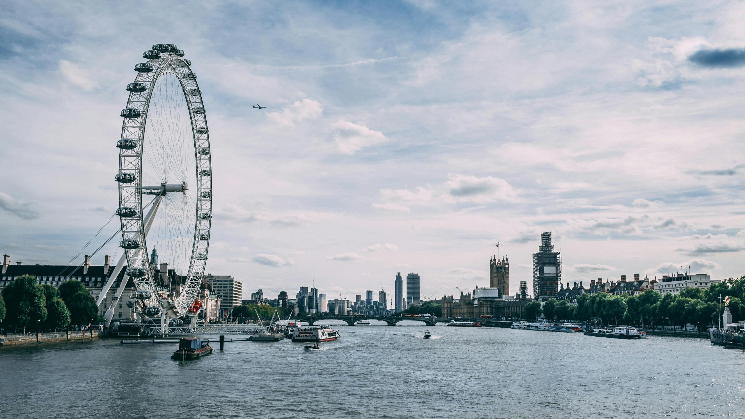 Het reuzenrad London Eye aan de oevers van de rivier de Theems, met uitzicht op de Houses of Parliament en de Big Ben in de verte.