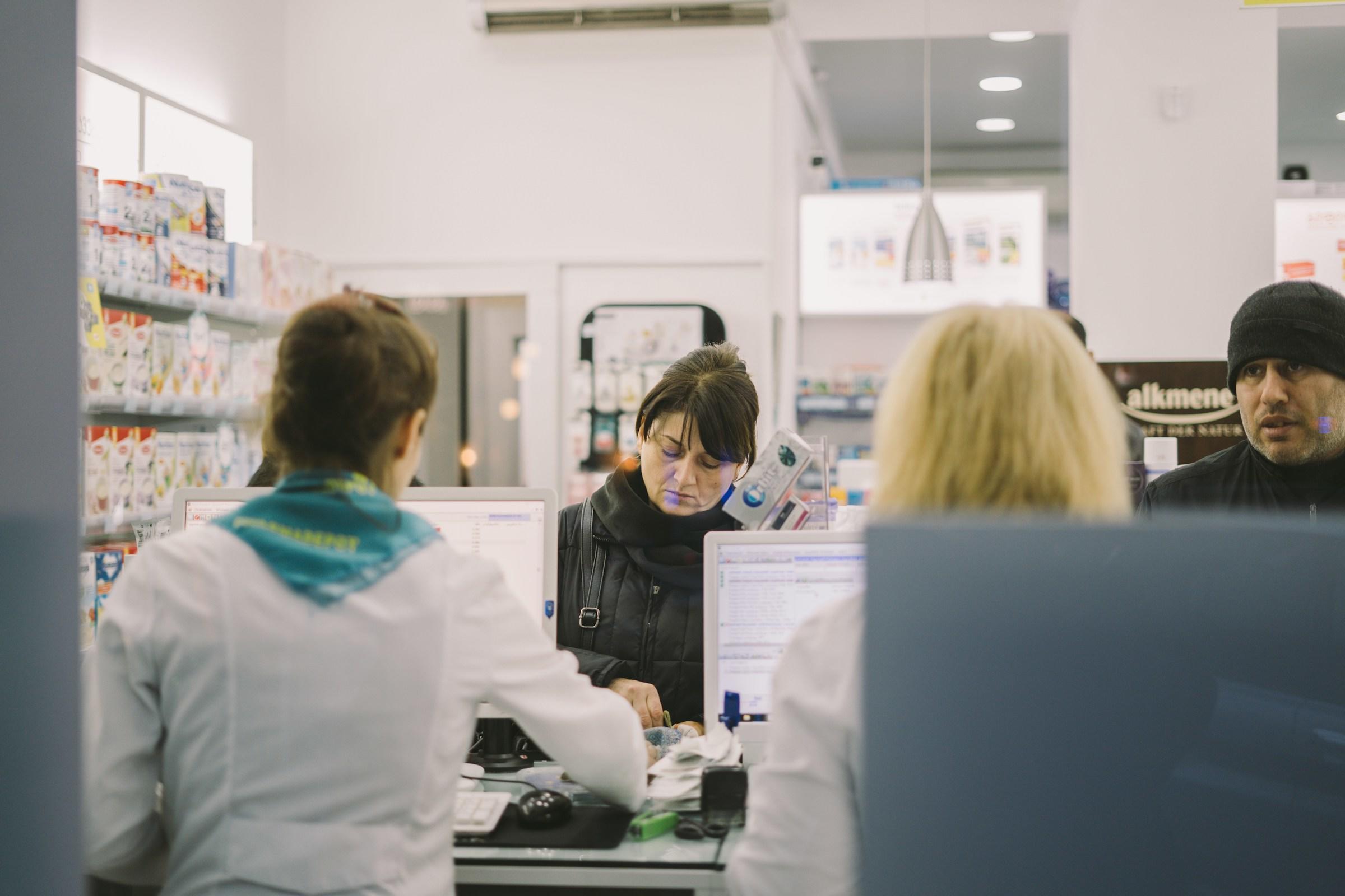 Mensen achter balie bij apotheek