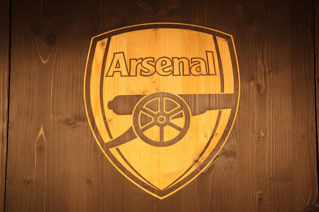 Arsenal clublogo op een houten achtergrond.