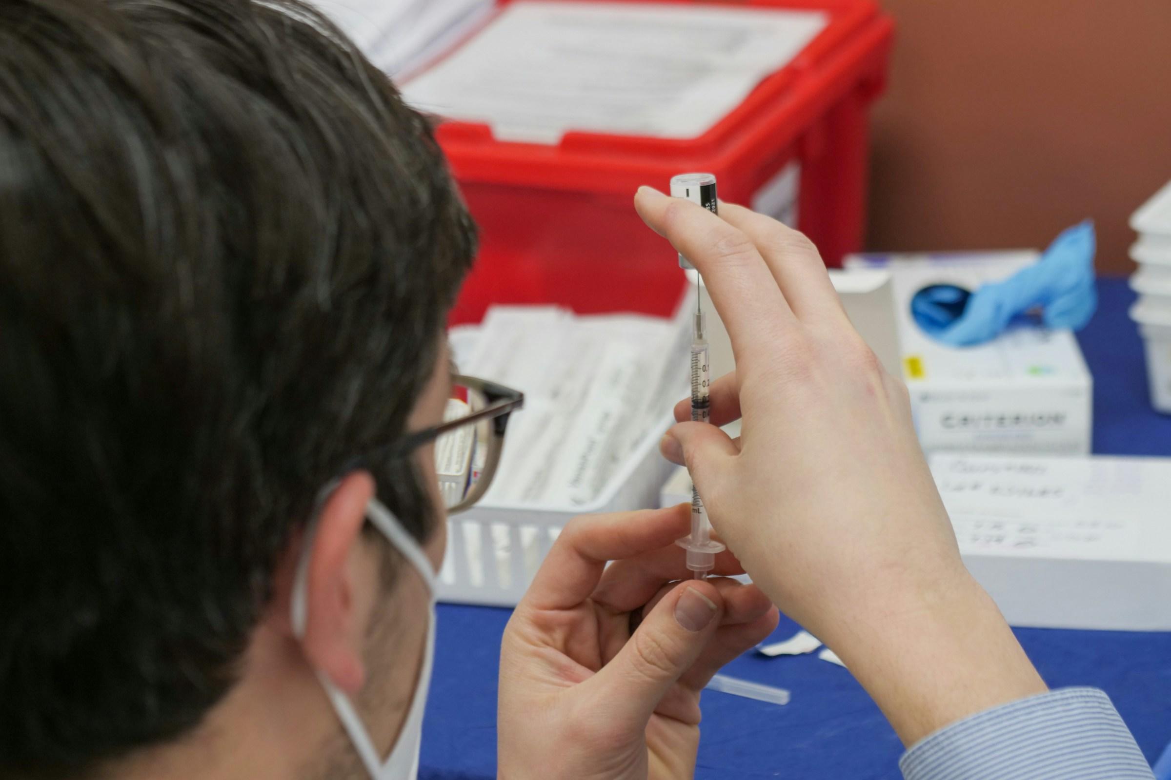 Persoon vult injectiespuit met vloeistof
