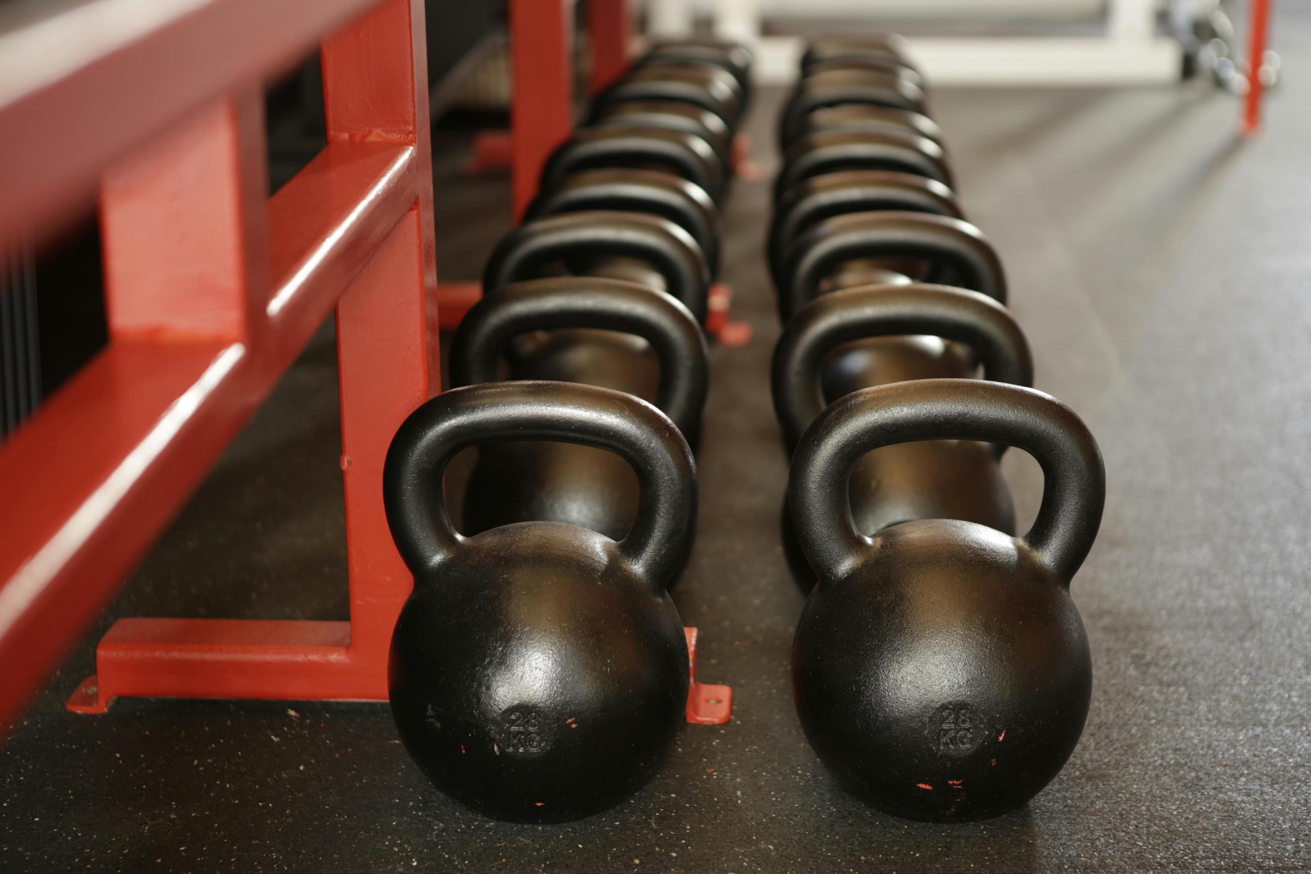 Zware kettlebells liggen netjes op een rij in de fitnessruimte.