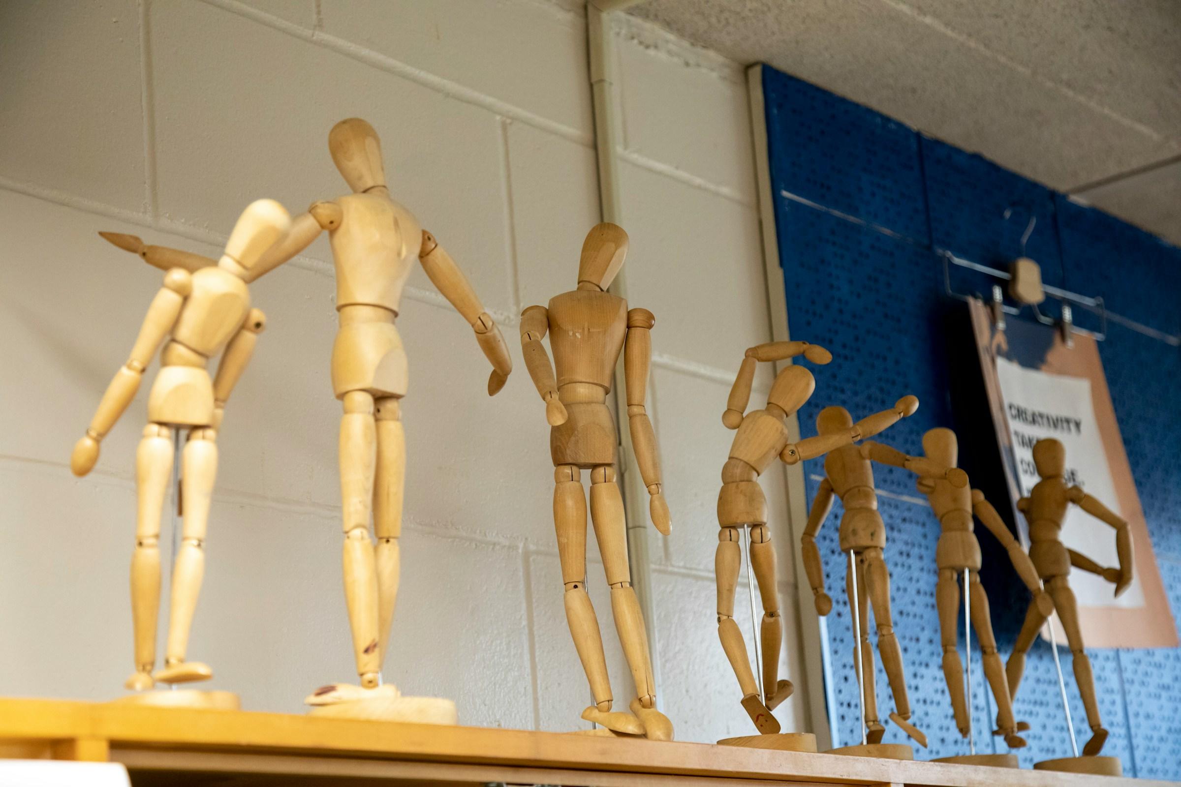 Anatomische beeldjes in verschillende houdingen op een plank