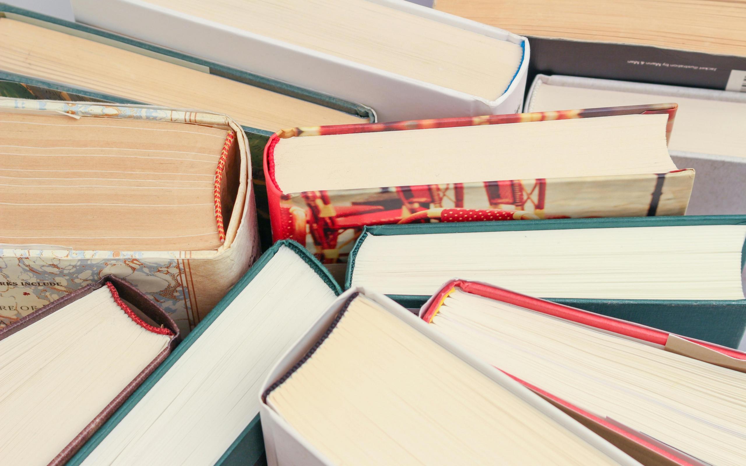 Een verzameling boeken, dicht tegen elkaar aan, vanuit een bovenaanzicht.