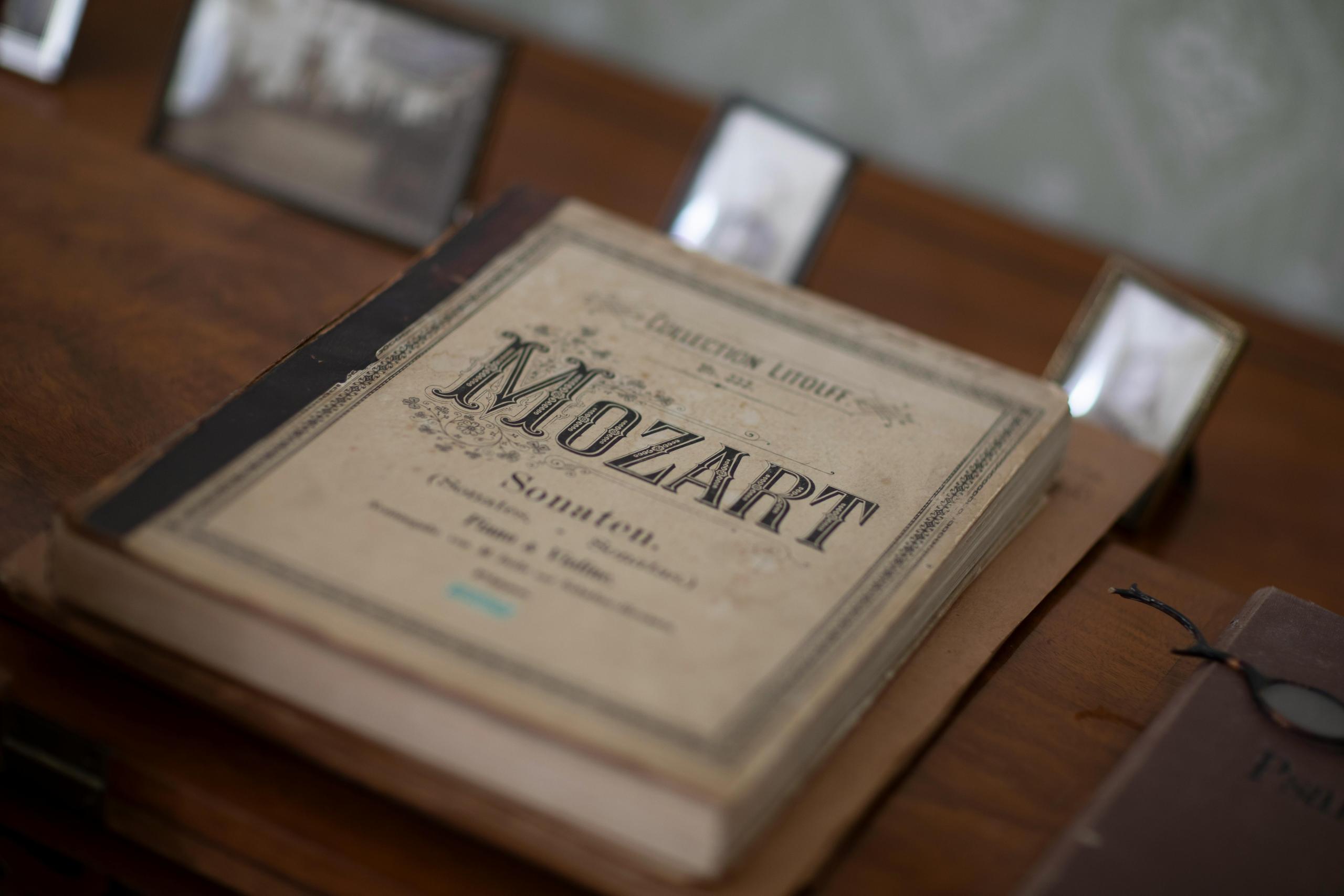 Een oude muziekpartituur van Mozart, liggend op een houten tafel.