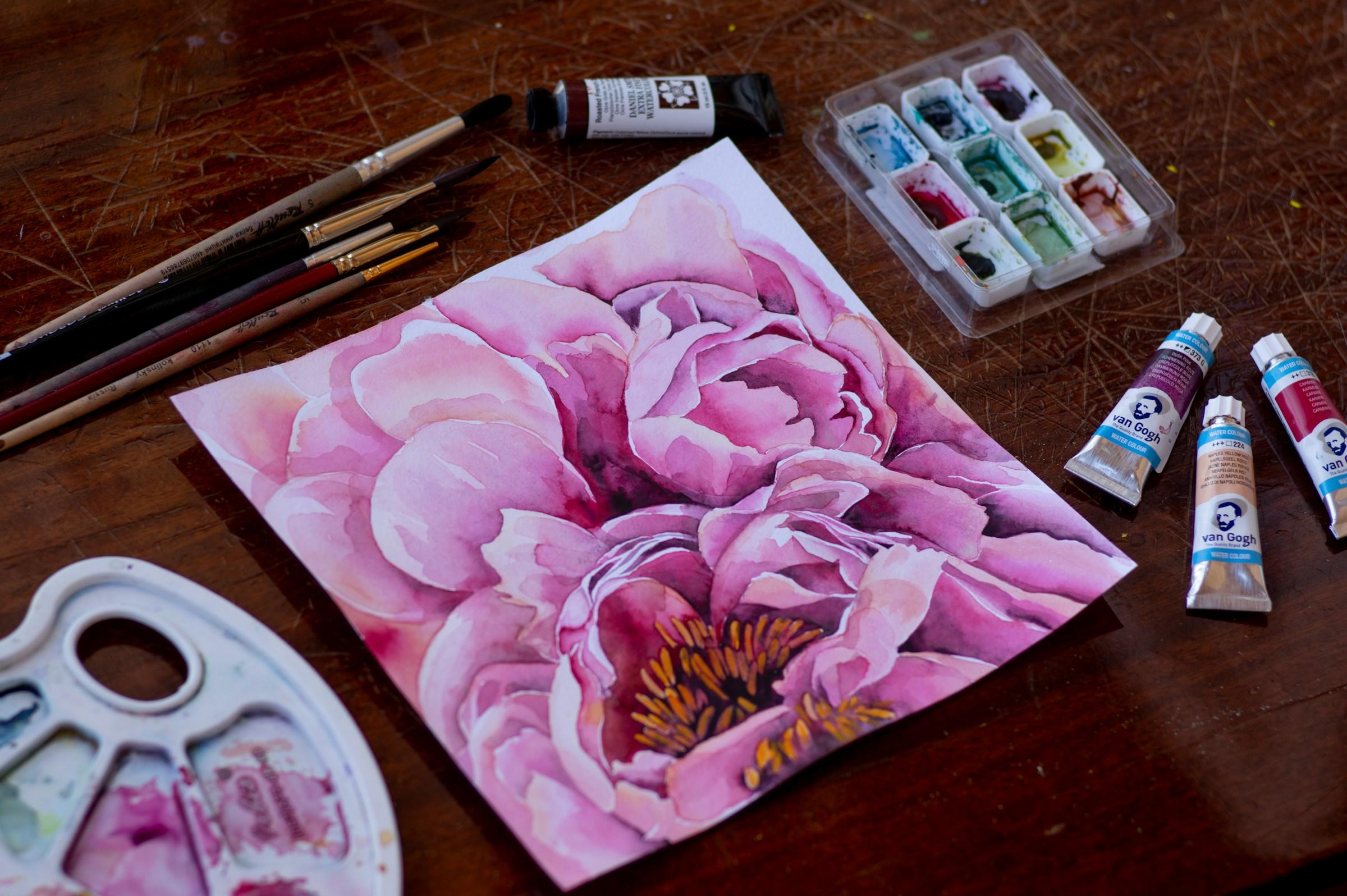 Aquarel met er omheen verf en penselen