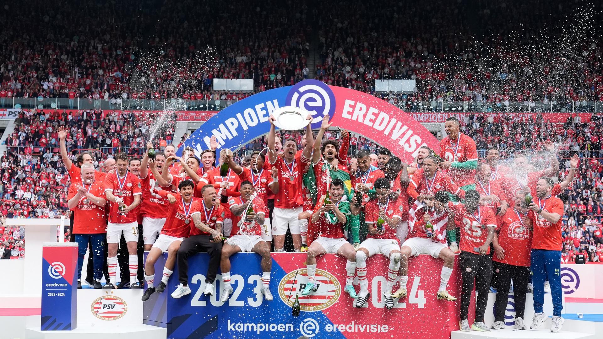 Een explosie van vreugde op het podium met het kampioensbord in handen van de spelers.