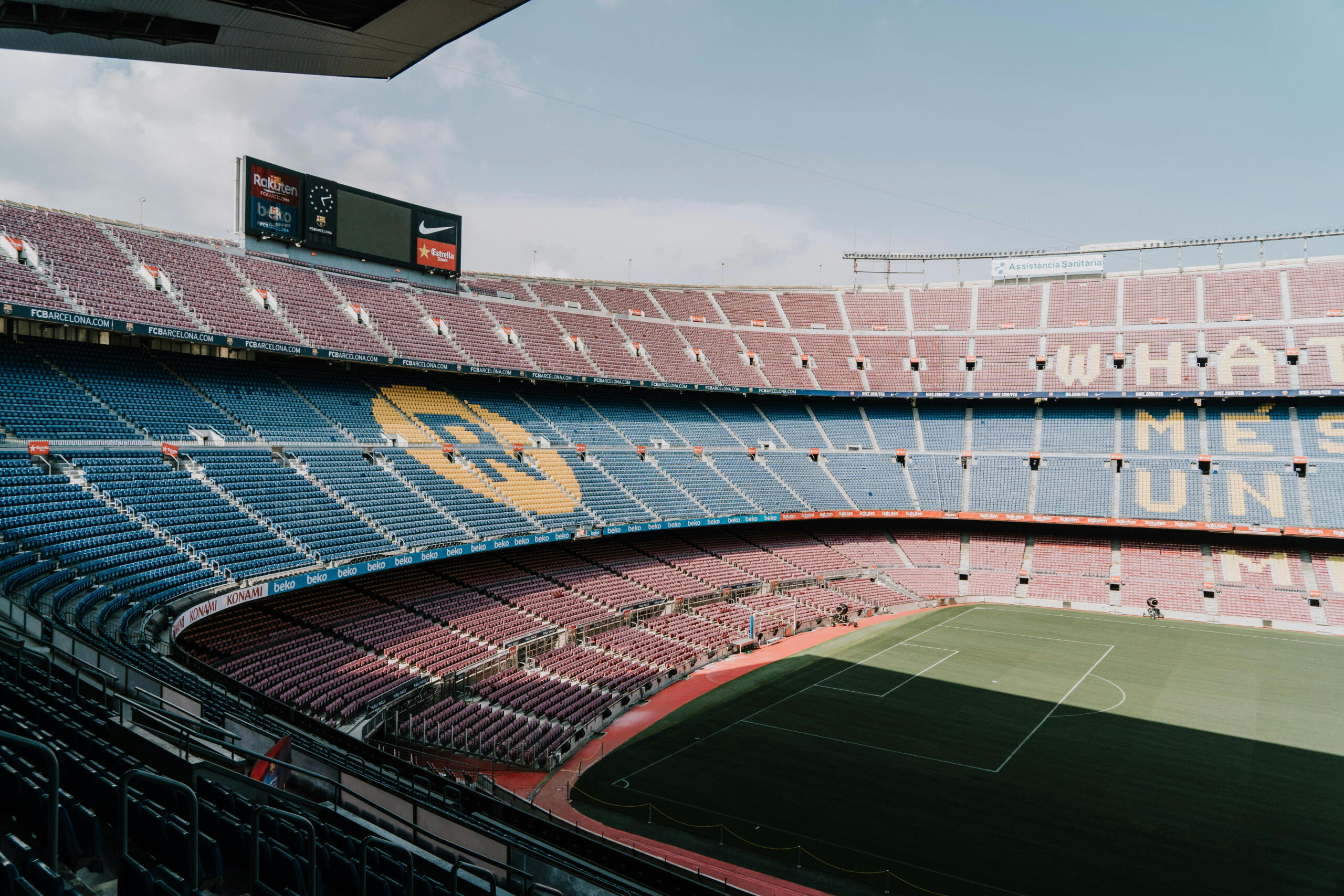 Camp Nou: leeg stadion van FC Barcelona, rode en blauwe stoelen, clublogo zichtbaar op tribunes.