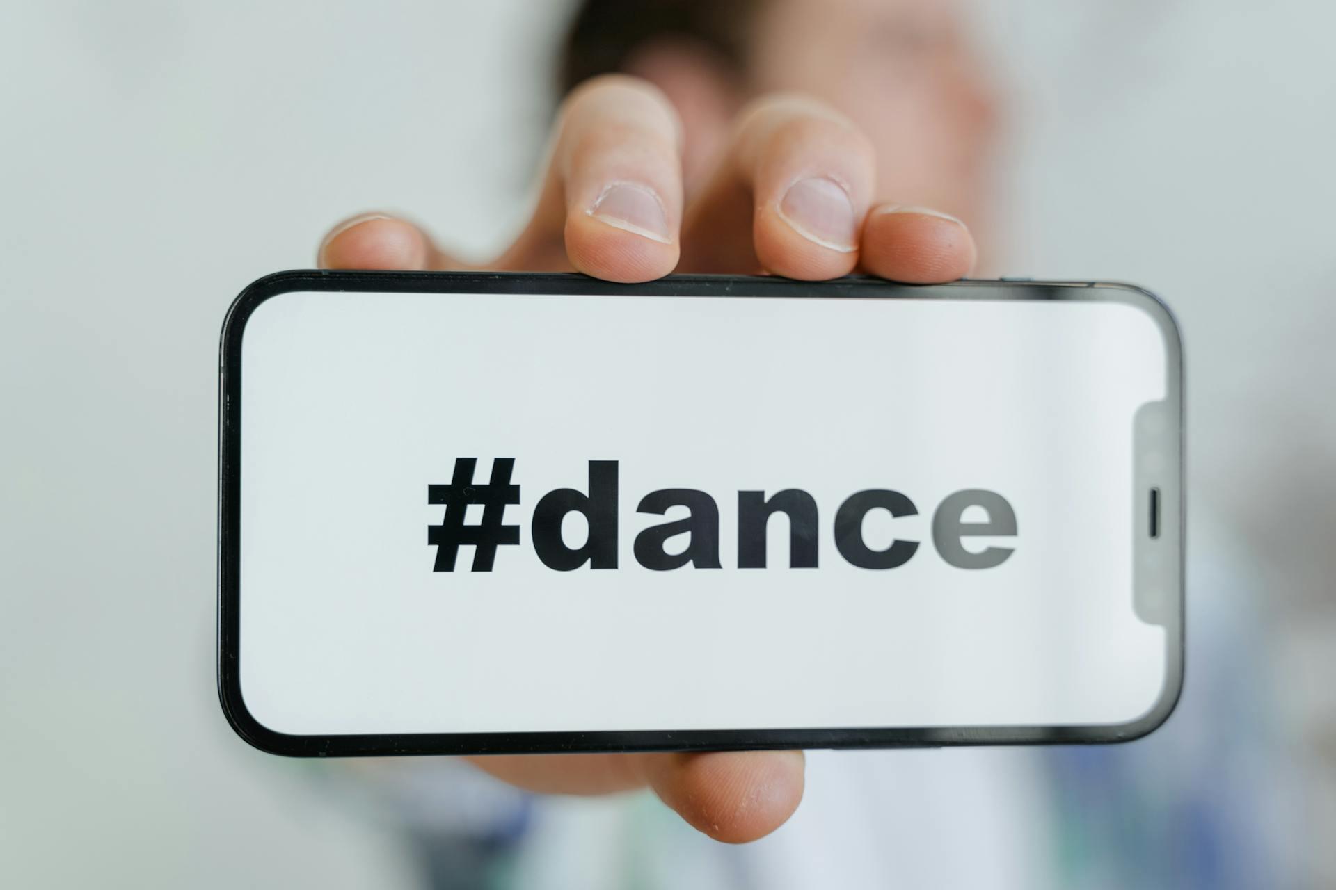 Hand houd smartphone met '#dance' vast