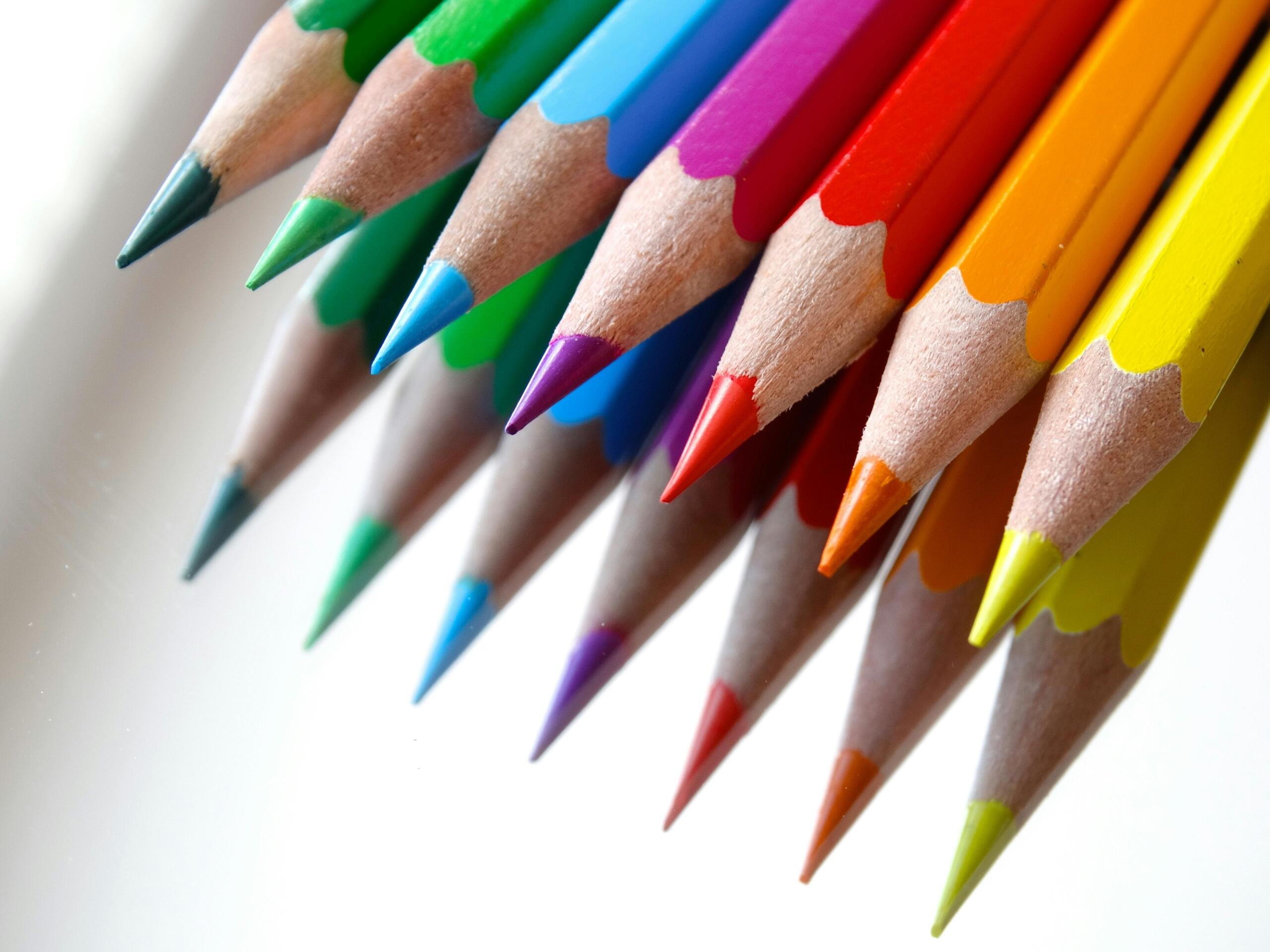 Een set kleurpotloden in regenboogkleuren, netjes gerangschikt met de punten naar voren gericht.