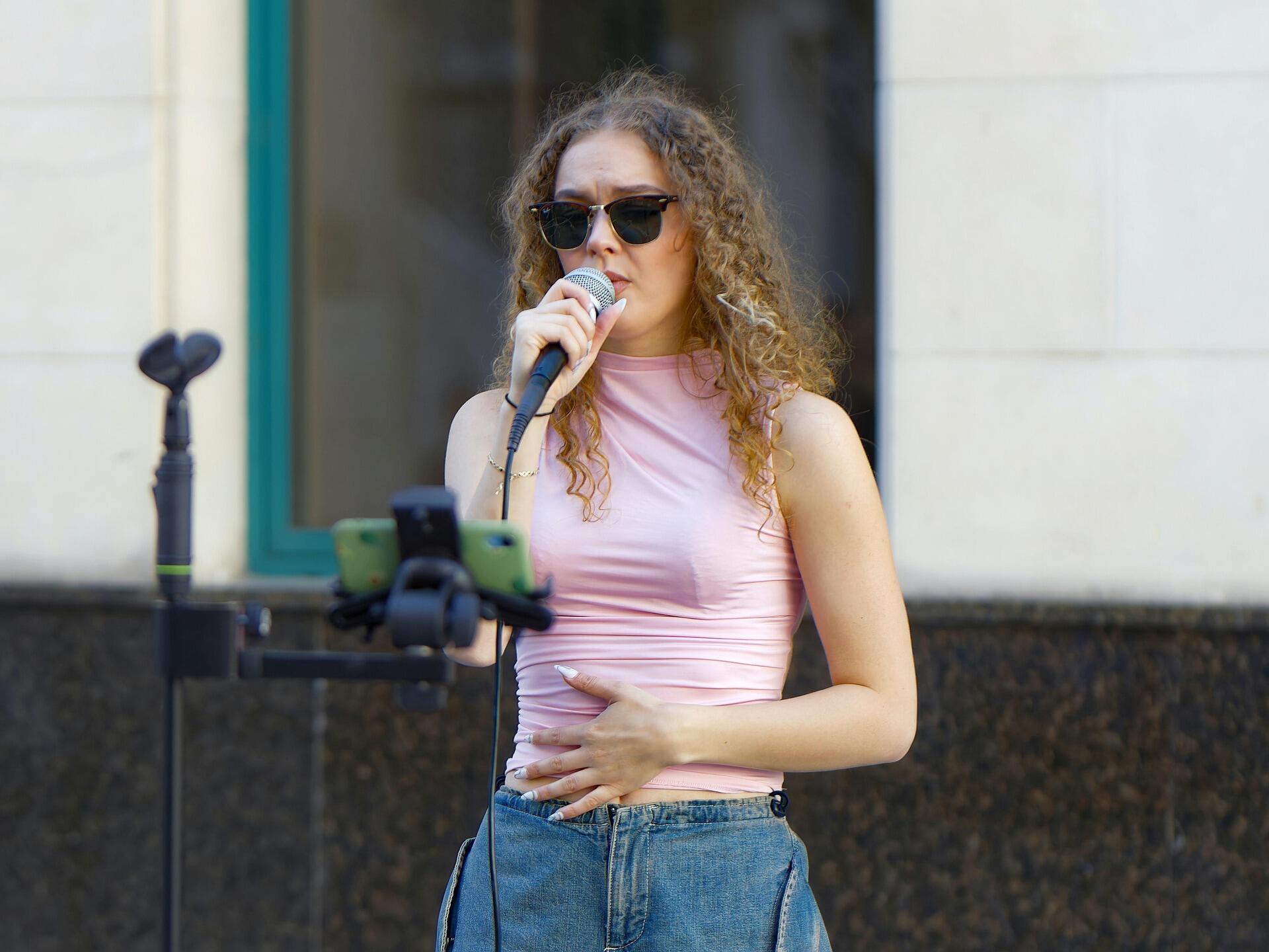 Persoon met zonnebril op zingt in microfoon