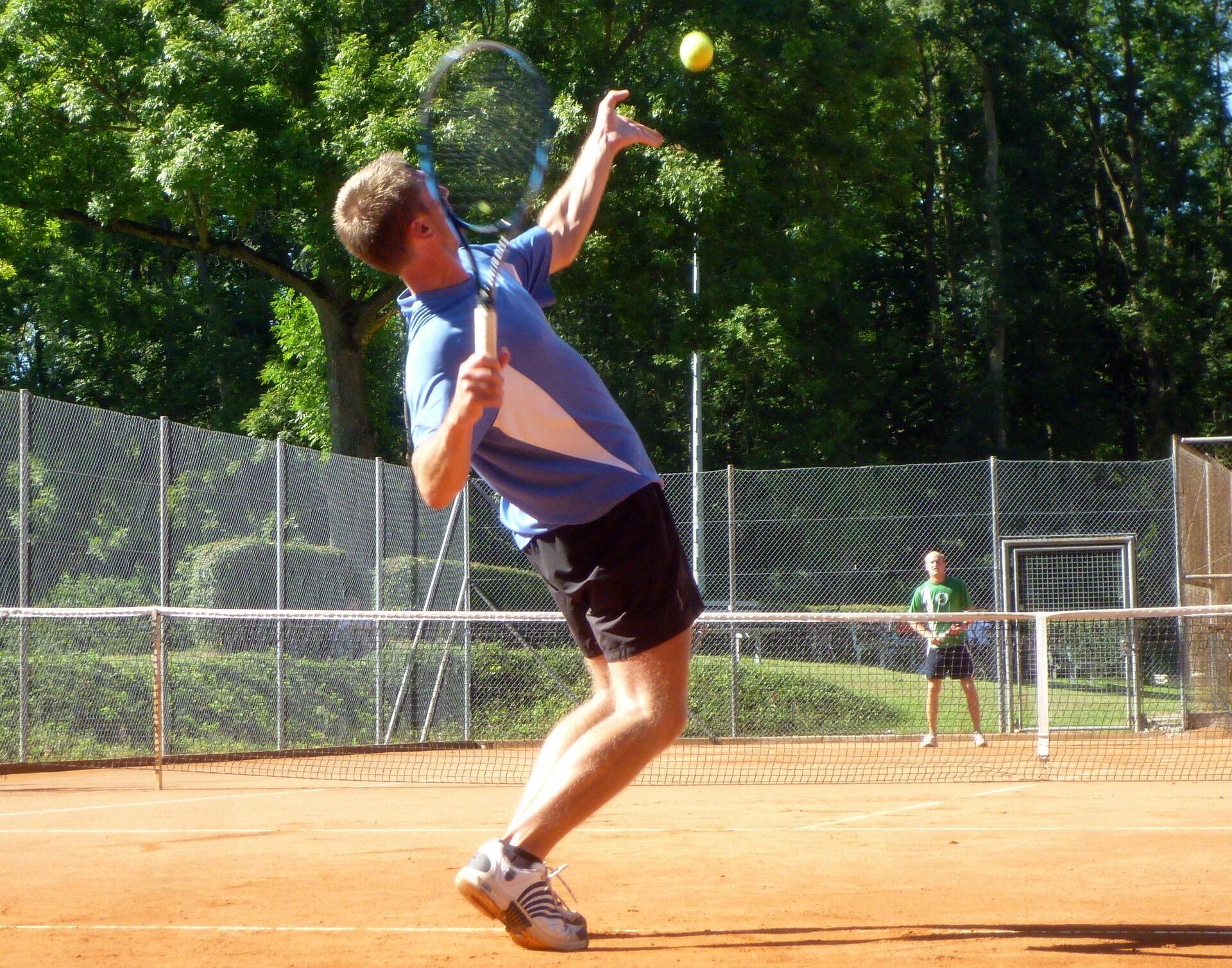 Persoon slaat bal op bij tennis