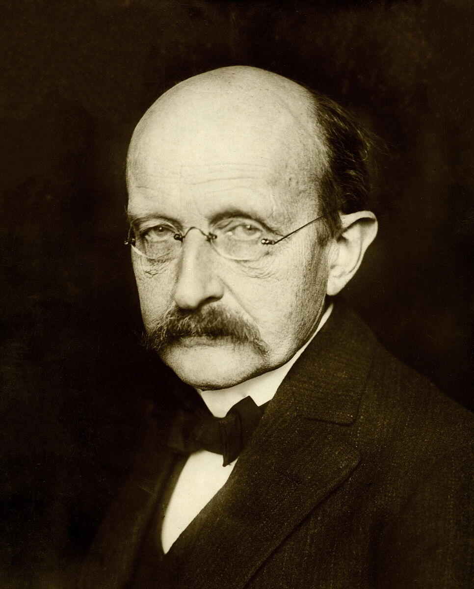 Zwart-witportret van Max Planck, zittend en kijkend naar de camera met een serieuze uitdrukking.​