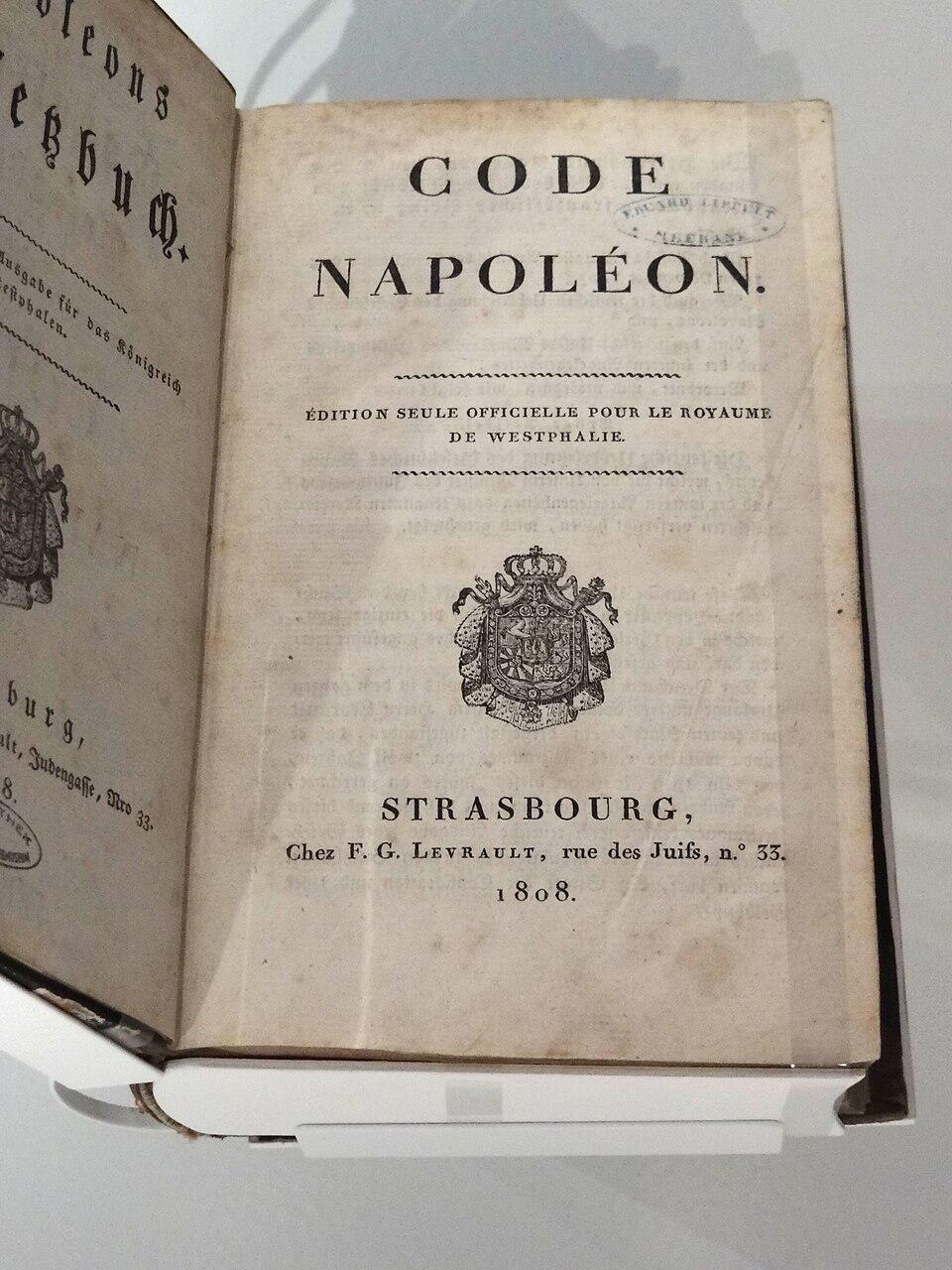Een openliggend boek met de titel "Code Napoléon", getoond in een glazen museumvitrine.