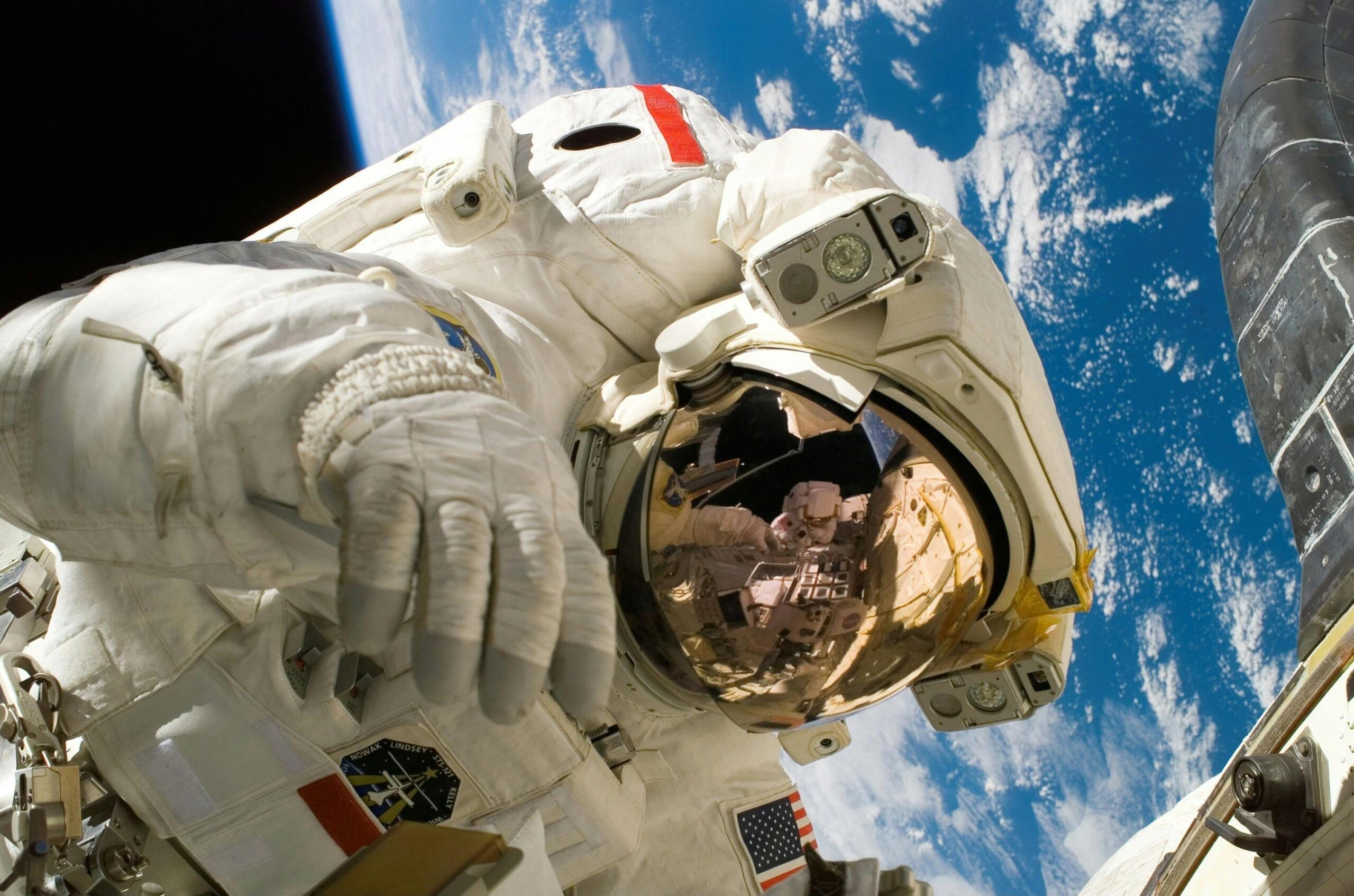 Een astronaut zweeft boven de aarde, met zijn helmreflectie en ruimtepakken-details duidelijk zichtbaar.